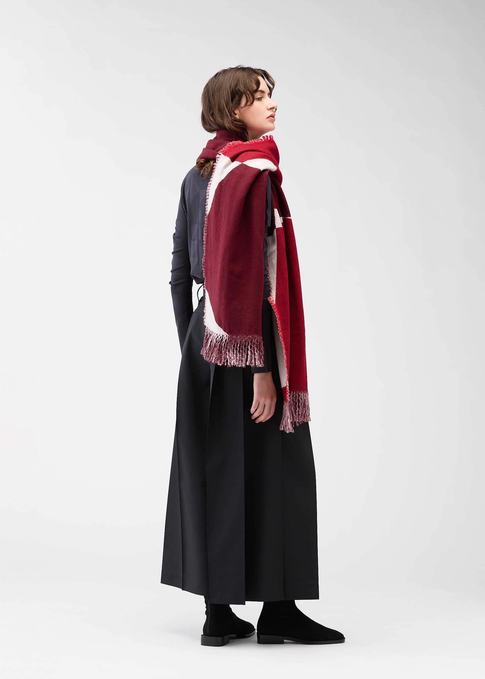 A model wears the 132 5. ISSEY MIYAKE POSITIONS STOLE stole.