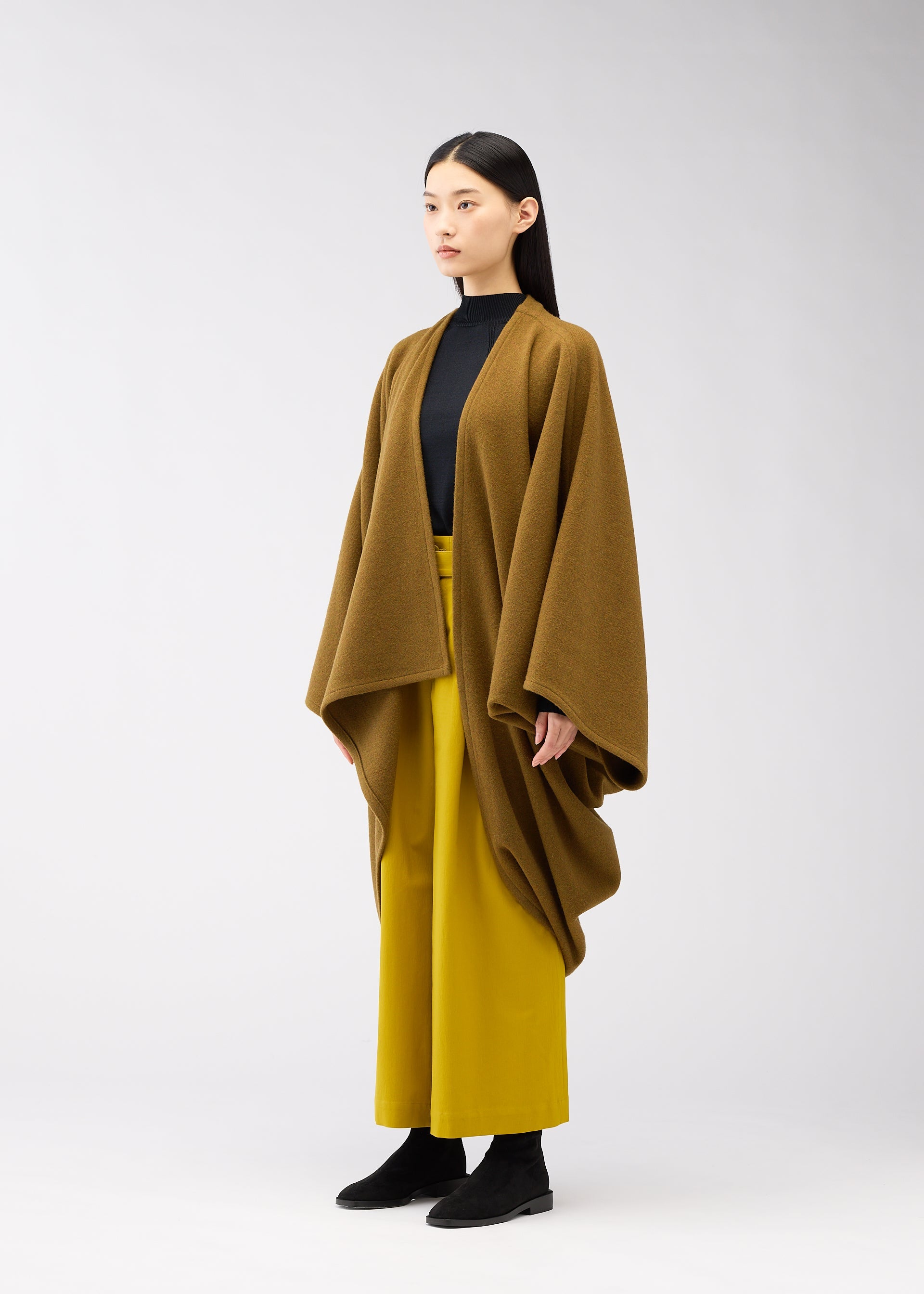 A model wears the 132 5. ISSEY MIYAKE DRAPE COAT coat.