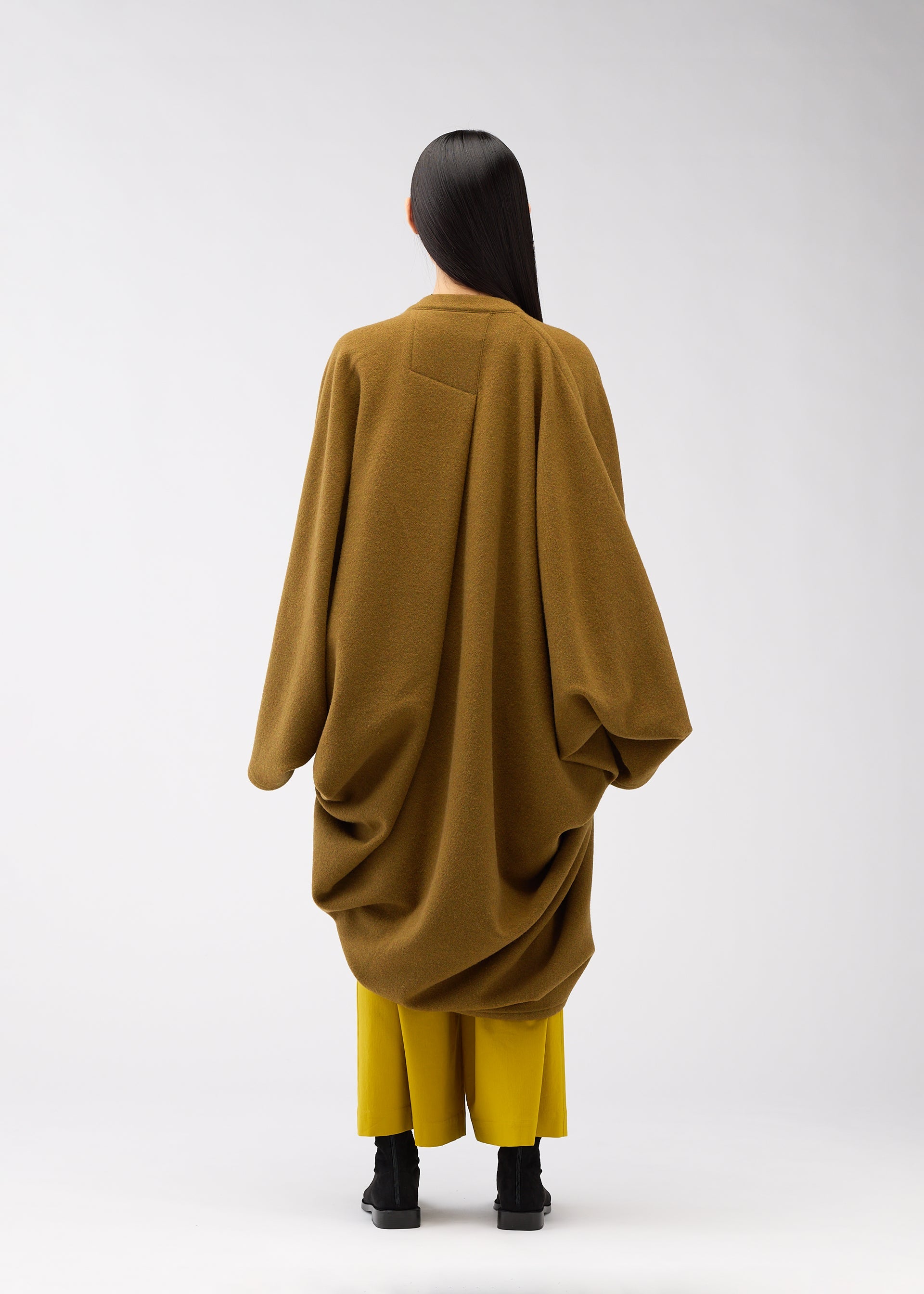 A model wears the 132 5. ISSEY MIYAKE DRAPE COAT coat.