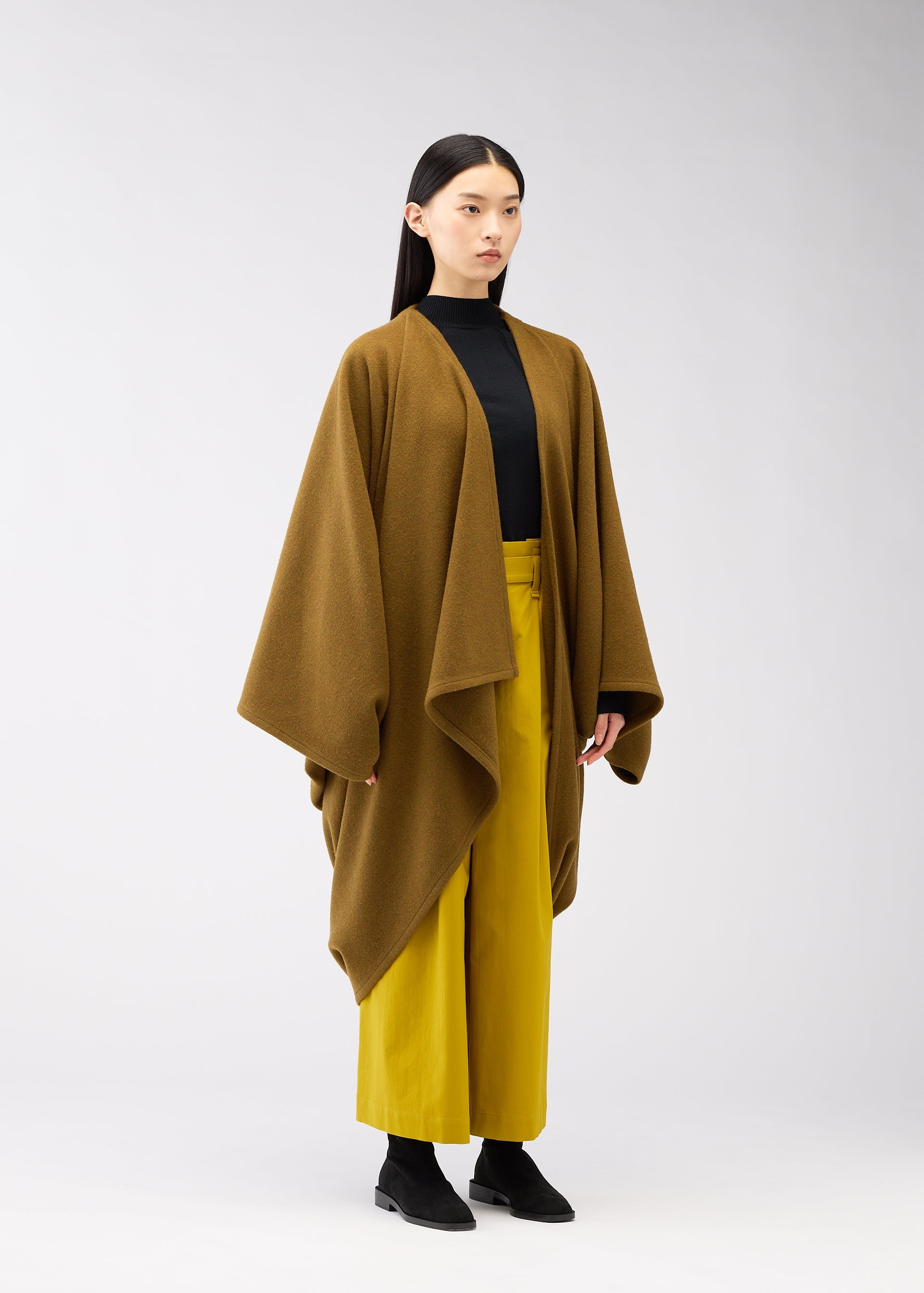 A model wears the 132 5. ISSEY MIYAKE DRAPE COAT coat.