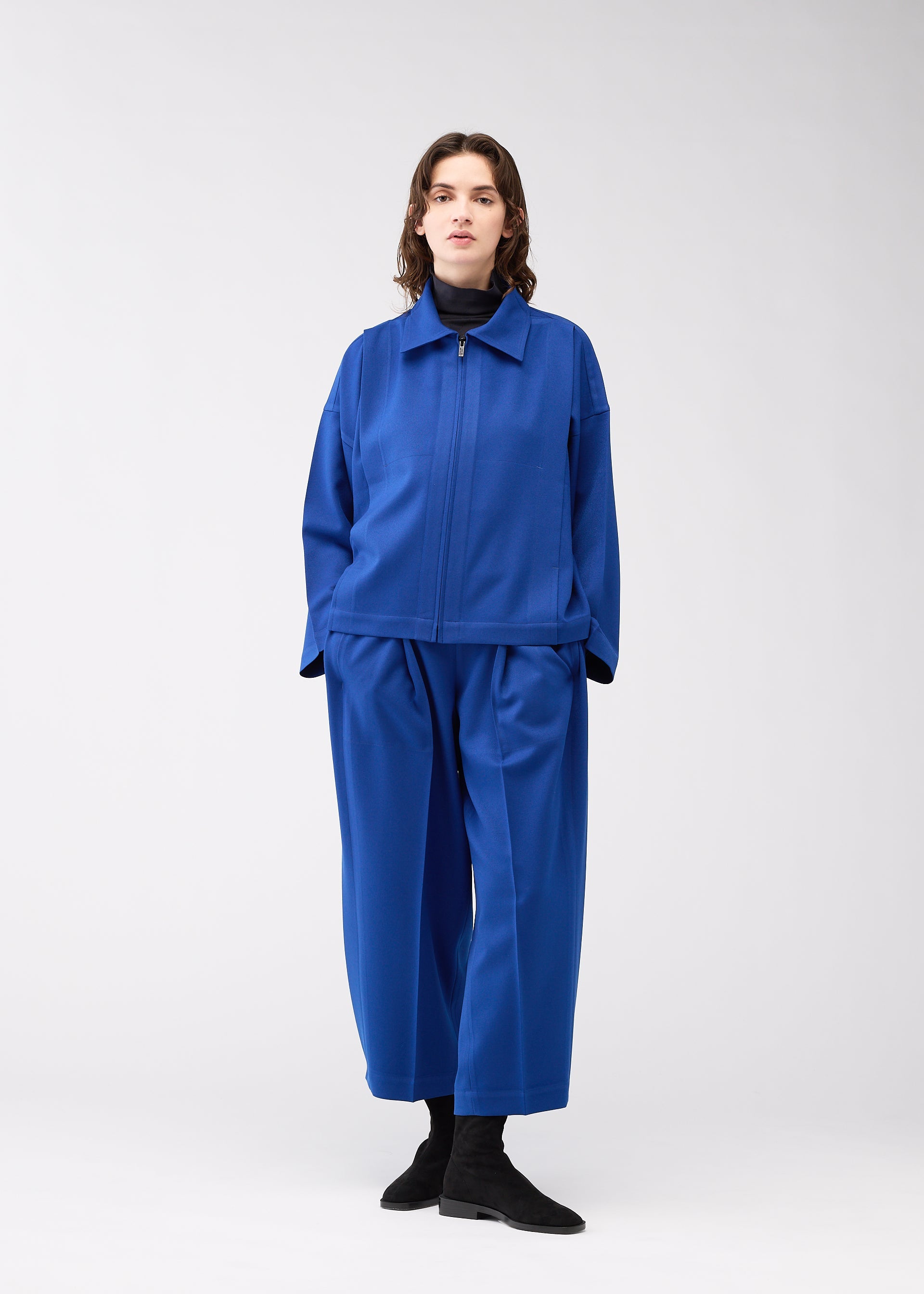 A model wears the 132 5. ISSEY MIYAKE WOOL LIKE FLAT TUCK jacket.