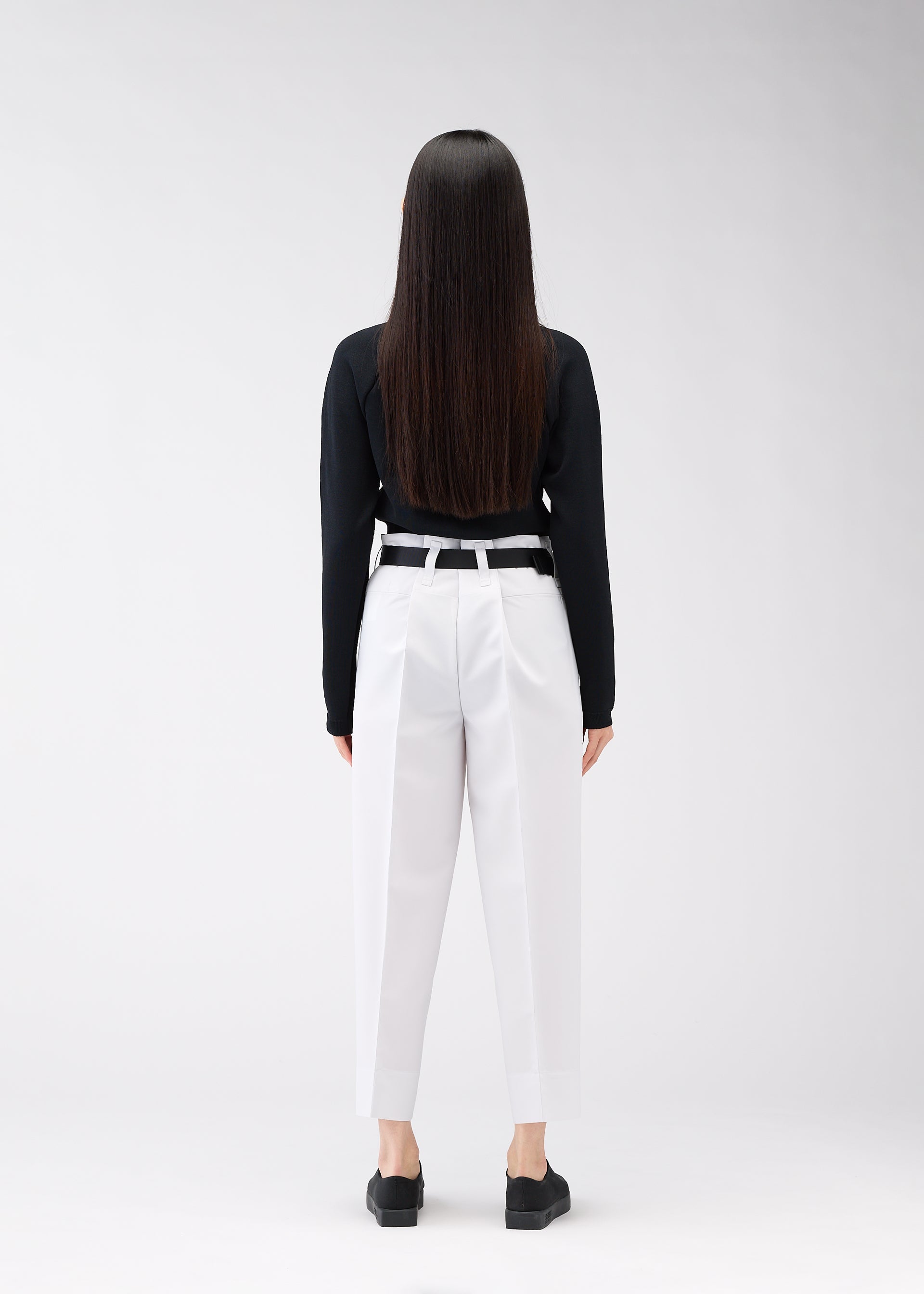 A model wears the 132 5. ISSEY MIYAKE 132 5. FLAT 1 trousers.
