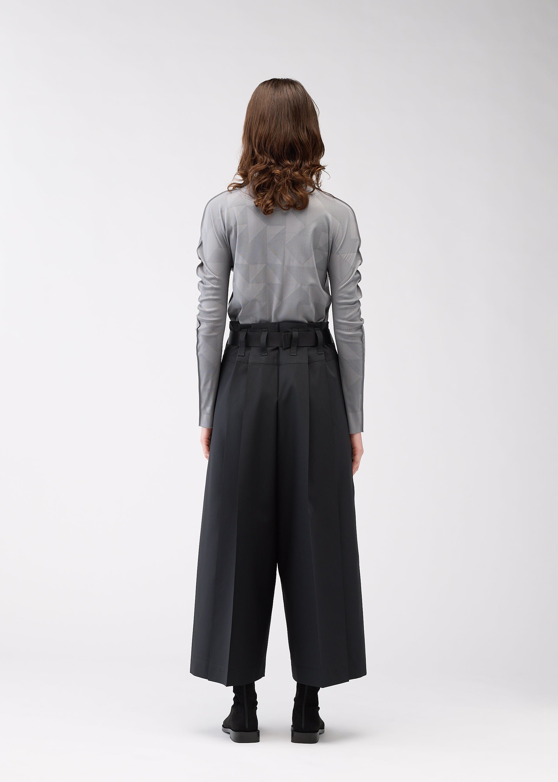A model wears the 132 5. ISSEY MIYAKE FLAT SIDE FOLD trousers.