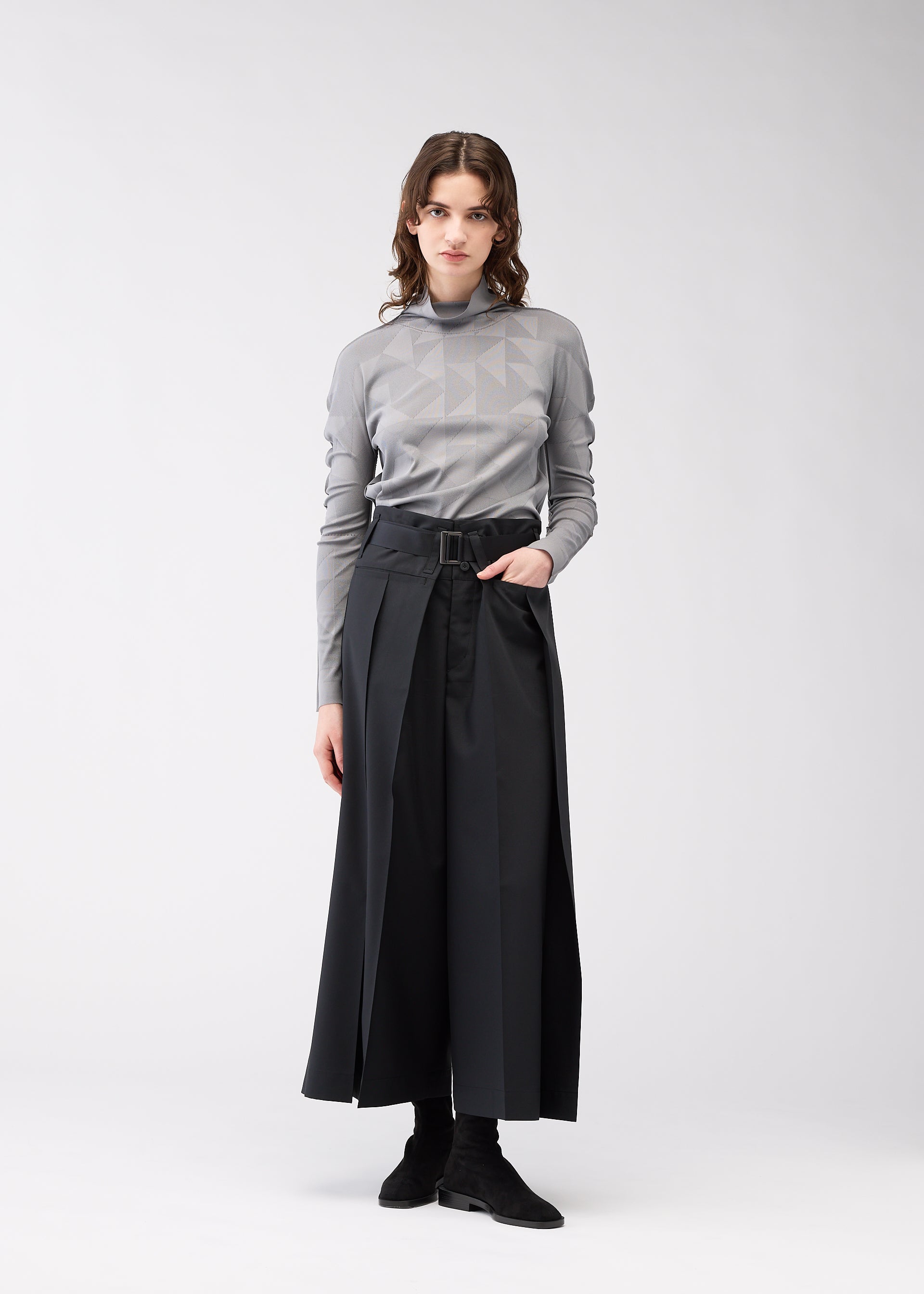 A model wears the 132 5. ISSEY MIYAKE FLAT SIDE FOLD trousers.