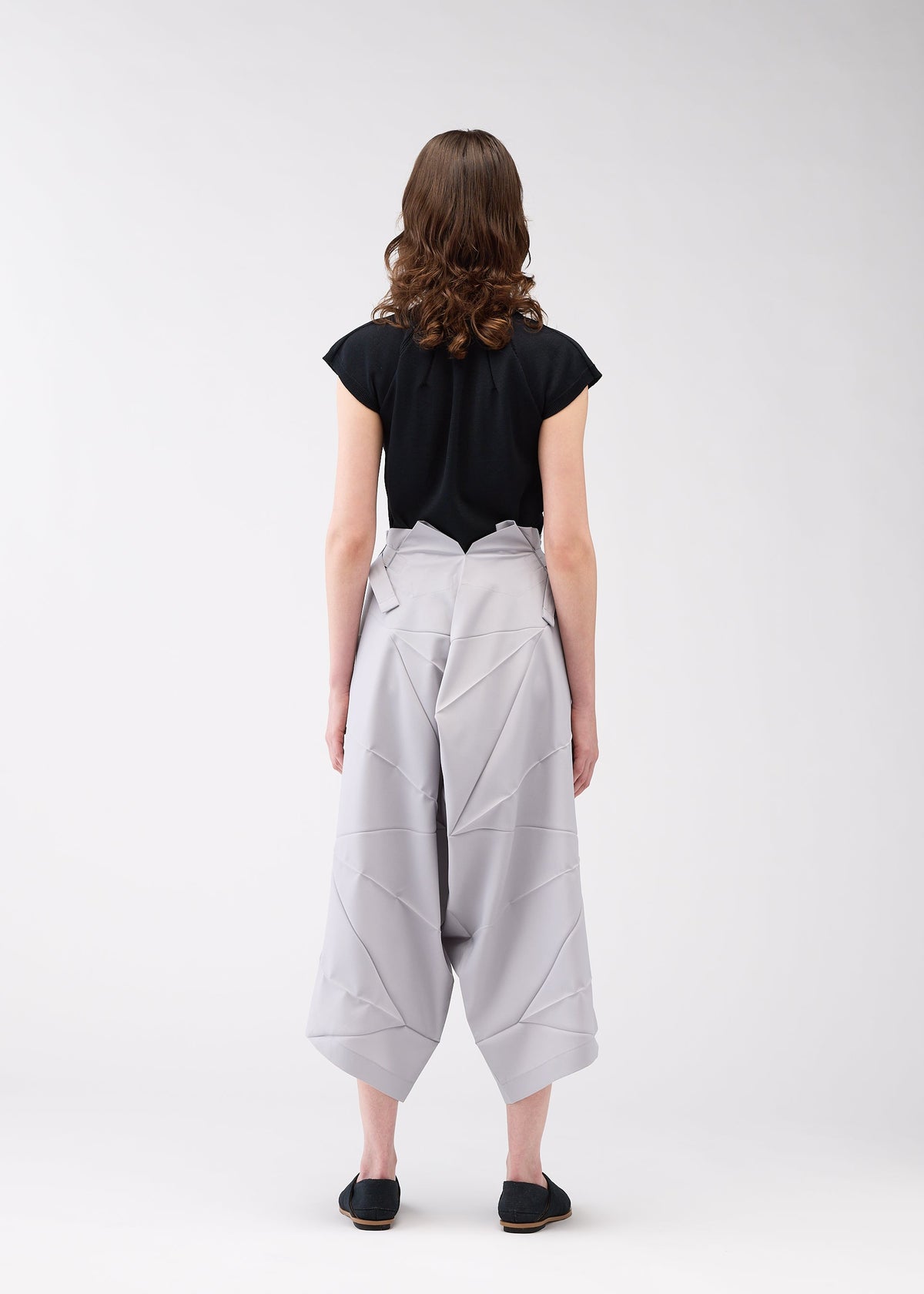 A model wears the 132 5. ISSEY MIYAKE NO.2 trousers.