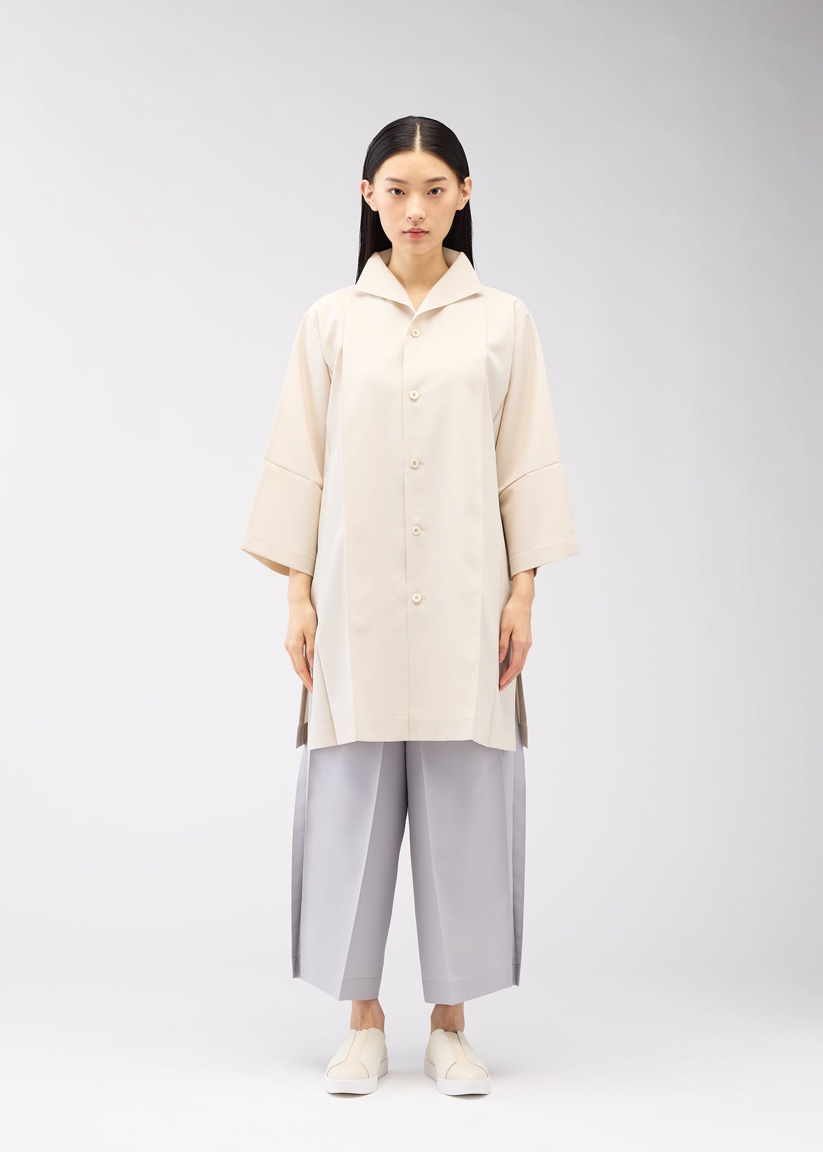 A model wears the 132 5. ISSEY MIYAKE FLAT SHIRTS shirt.