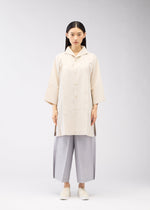 A model wears the 132 5. ISSEY MIYAKE FLAT SHIRTS shirt.