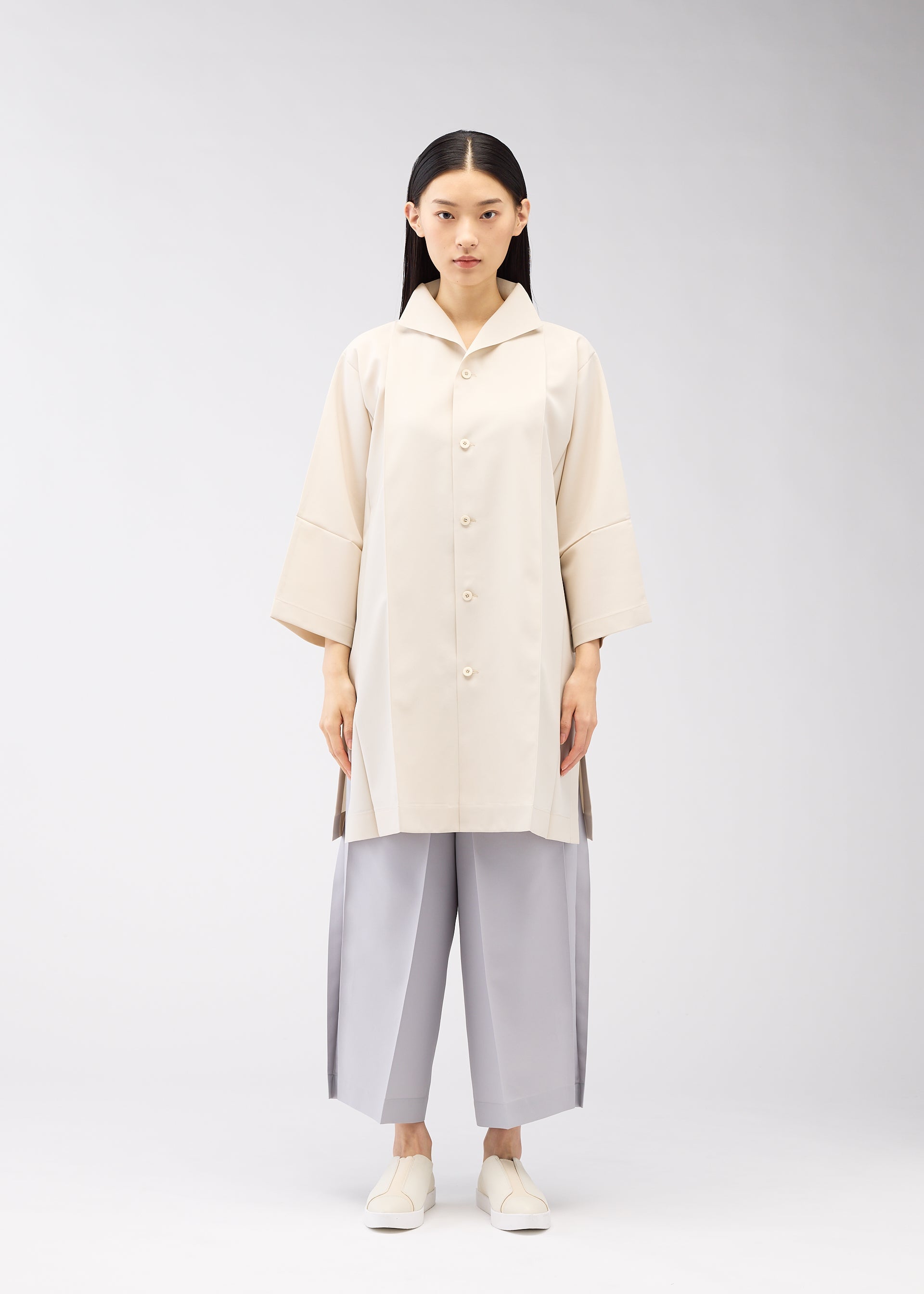 A model wears the 132 5. ISSEY MIYAKE FLAT SHIRTS shirt.
