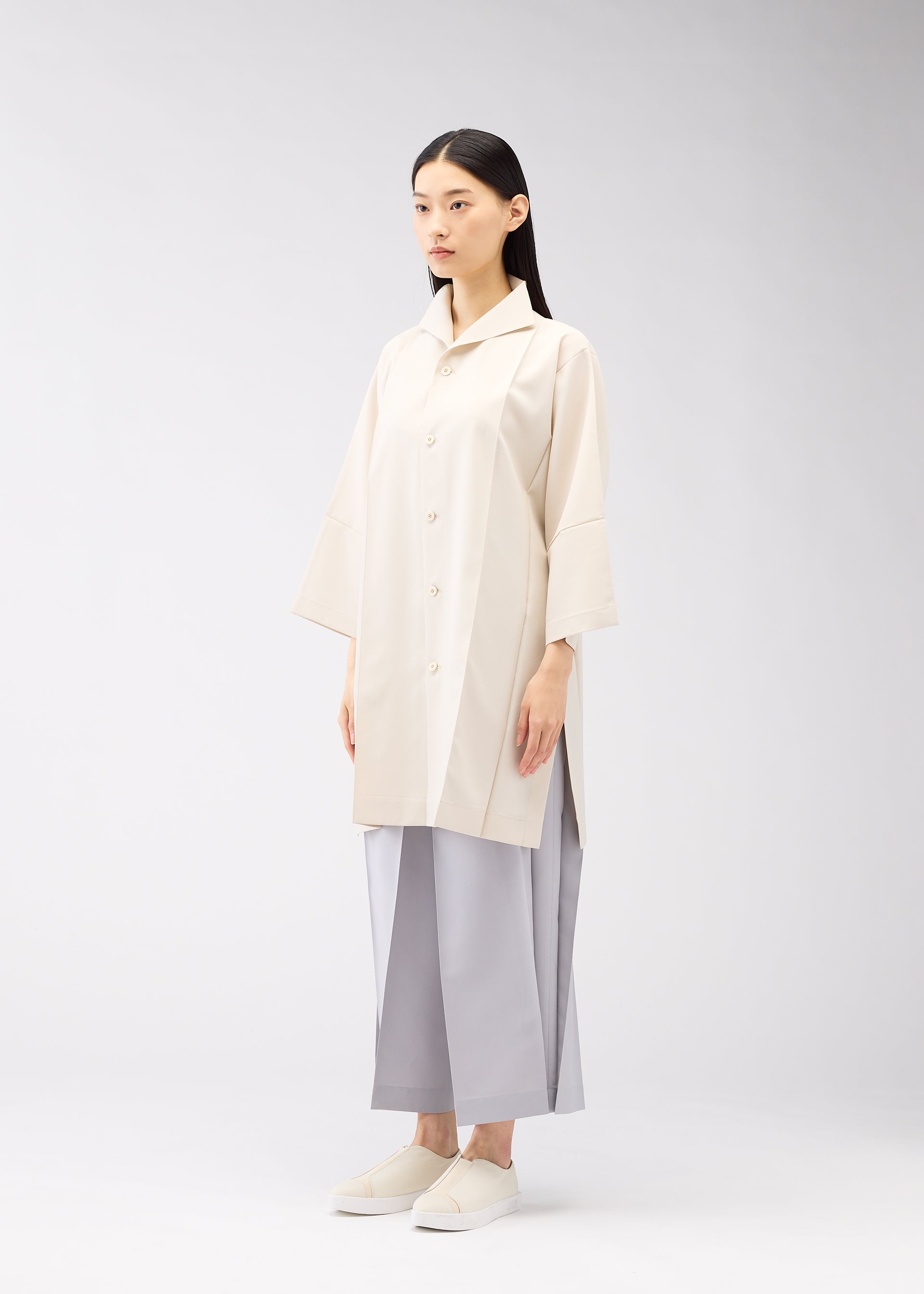 A model wears the 132 5. ISSEY MIYAKE FLAT SHIRTS shirt.