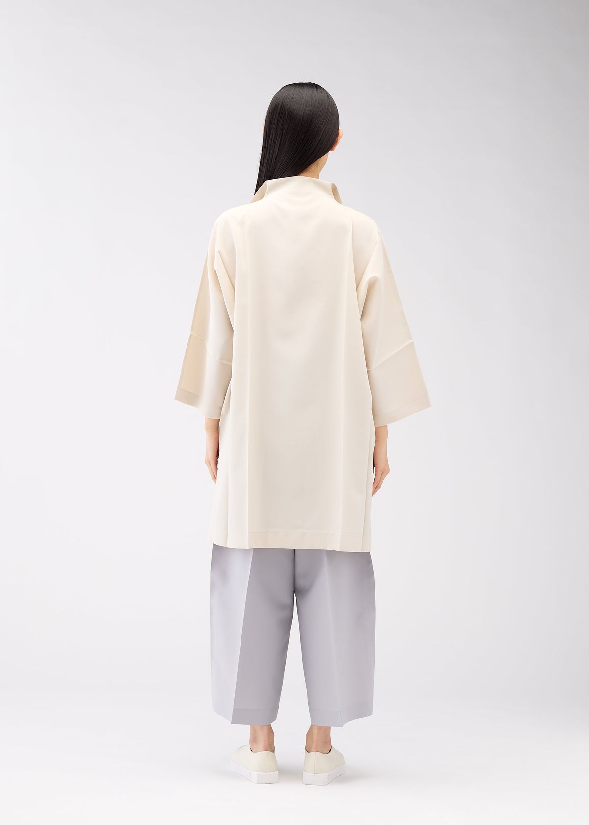A model wears the 132 5. ISSEY MIYAKE FLAT SHIRTS shirt.