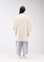 A model wears the 132 5. ISSEY MIYAKE FLAT SHIRTS shirt.
