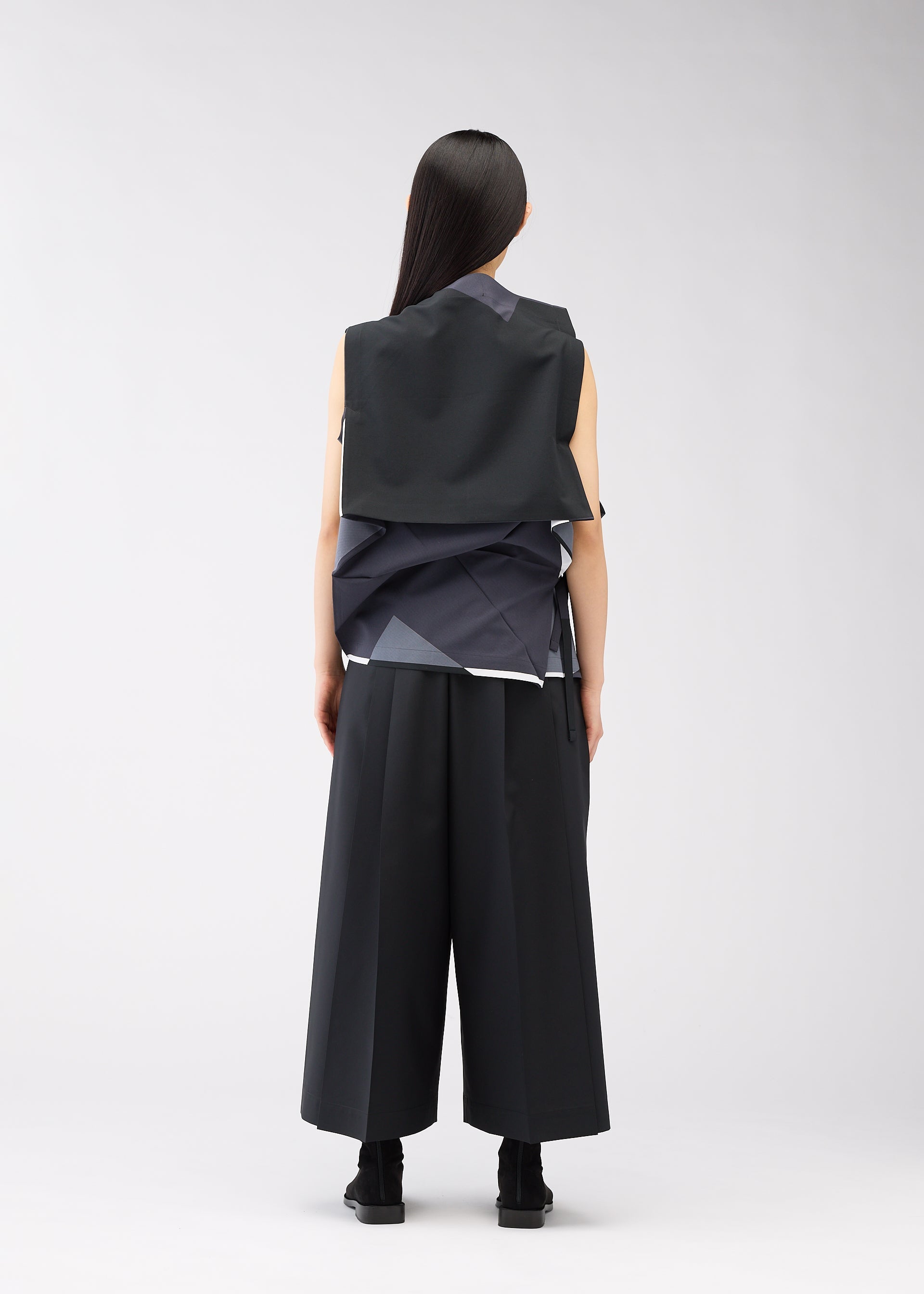 A model wears the 132 5. ISSEY MIYAKE POSITIONS shirt.