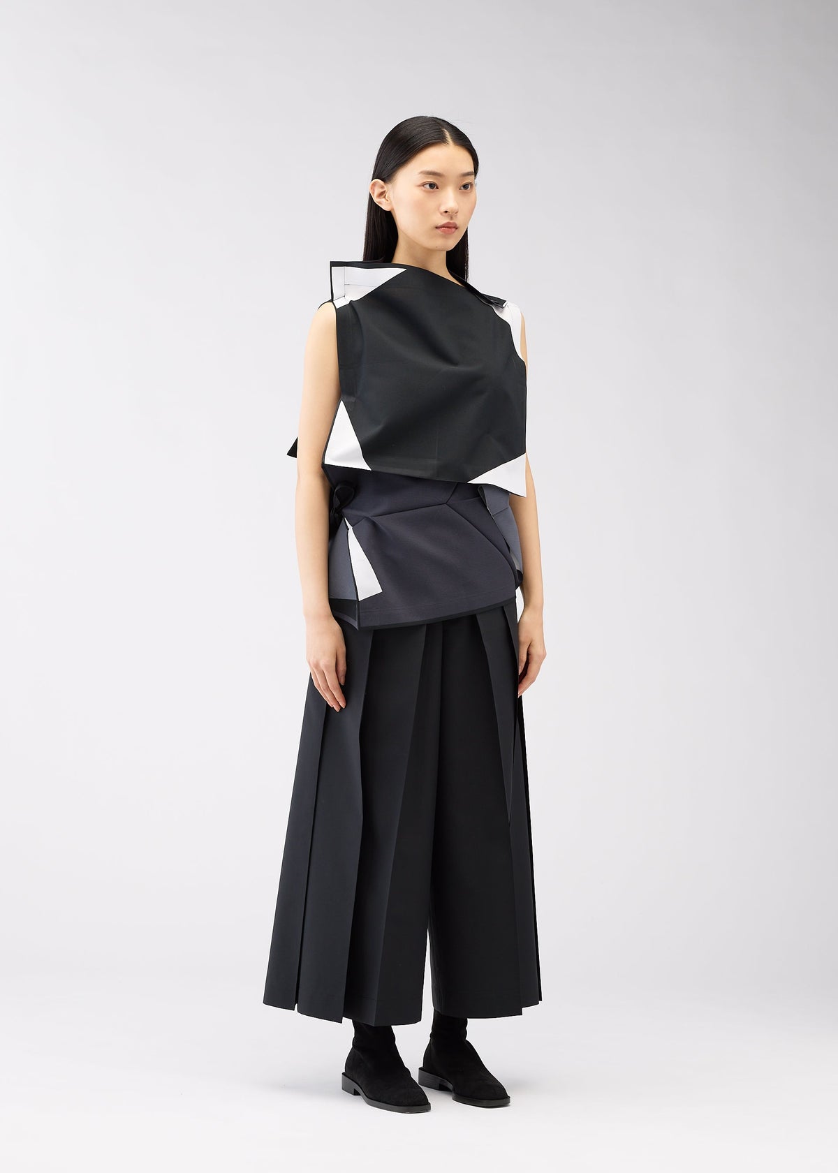 A model wears the 132 5. ISSEY MIYAKE POSITIONS shirt.