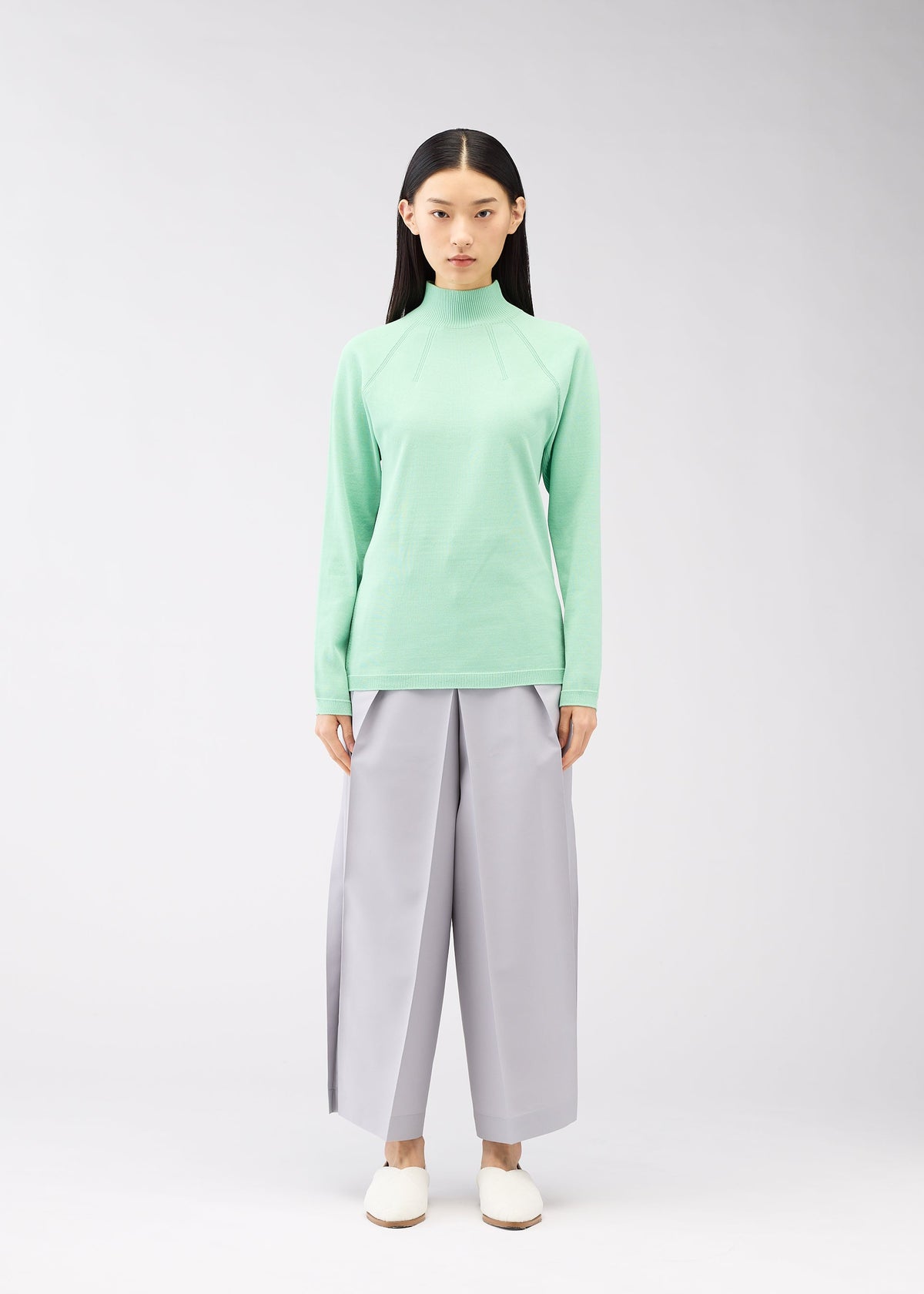 A model wears the 132 5. ISSEY MIYAKE DARTED KNIT top.