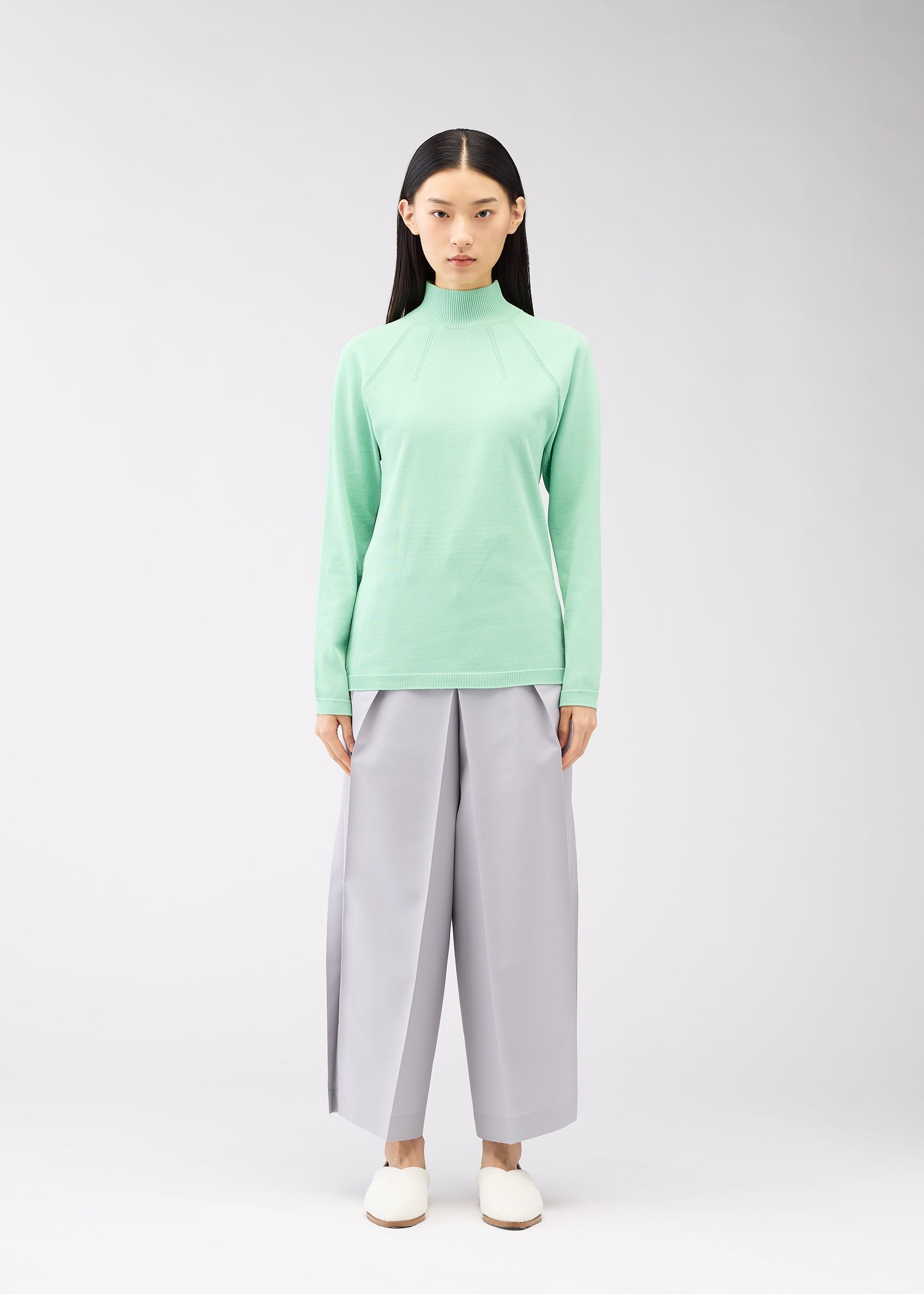 A model wears the 132 5. ISSEY MIYAKE DARTED KNIT top.