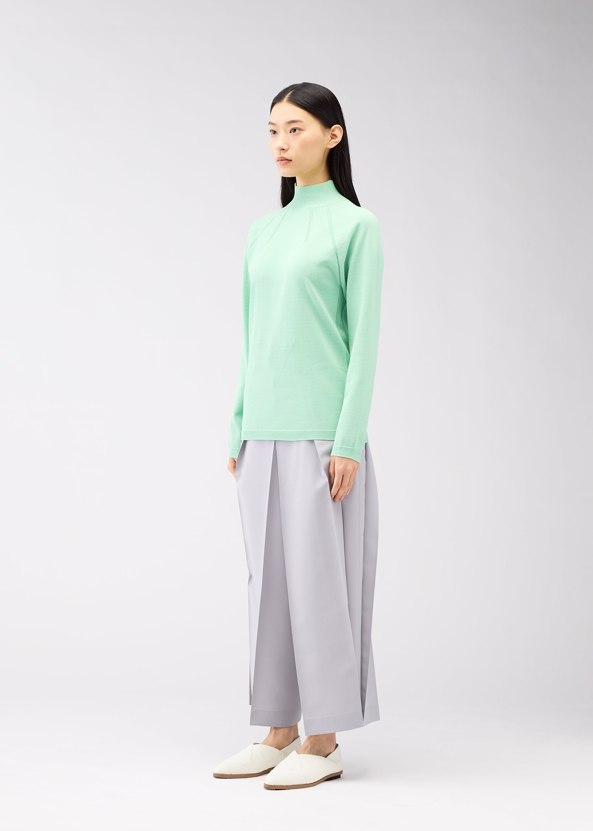 A model wears the 132 5. ISSEY MIYAKE DARTED KNIT top.