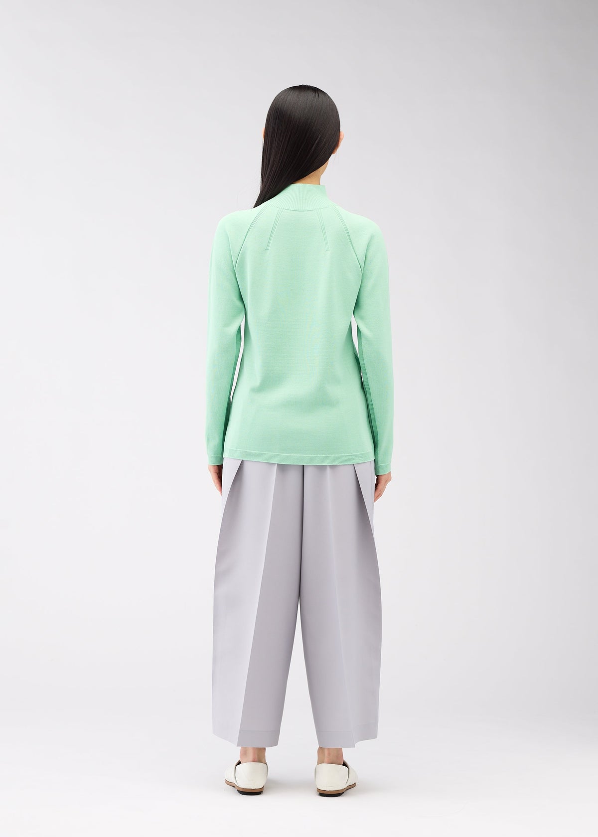 A model wears the 132 5. ISSEY MIYAKE DARTED KNIT top.