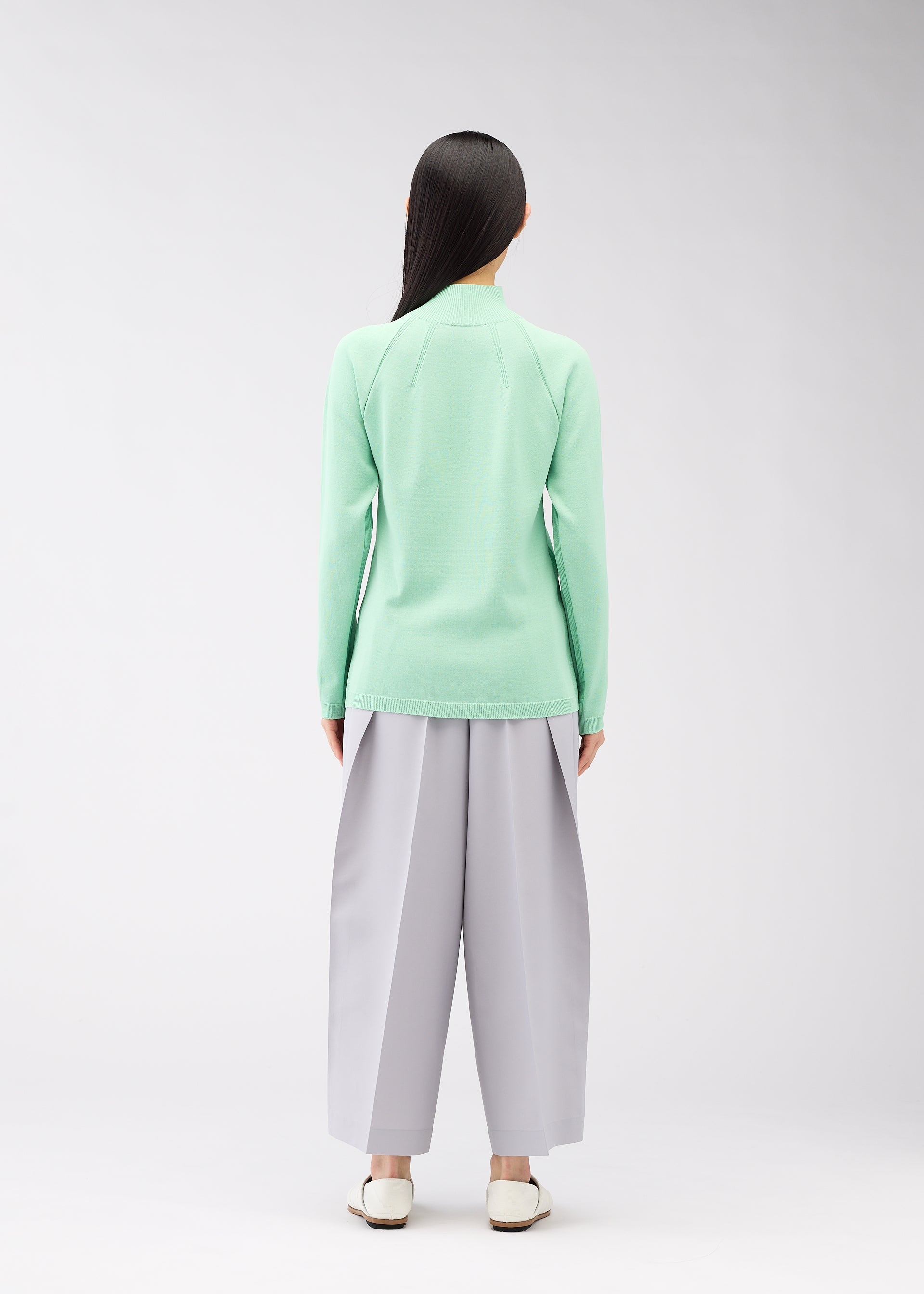 A model wears the 132 5. ISSEY MIYAKE DARTED KNIT top.