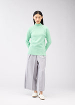 A model wears the 132 5. ISSEY MIYAKE DARTED KNIT top.