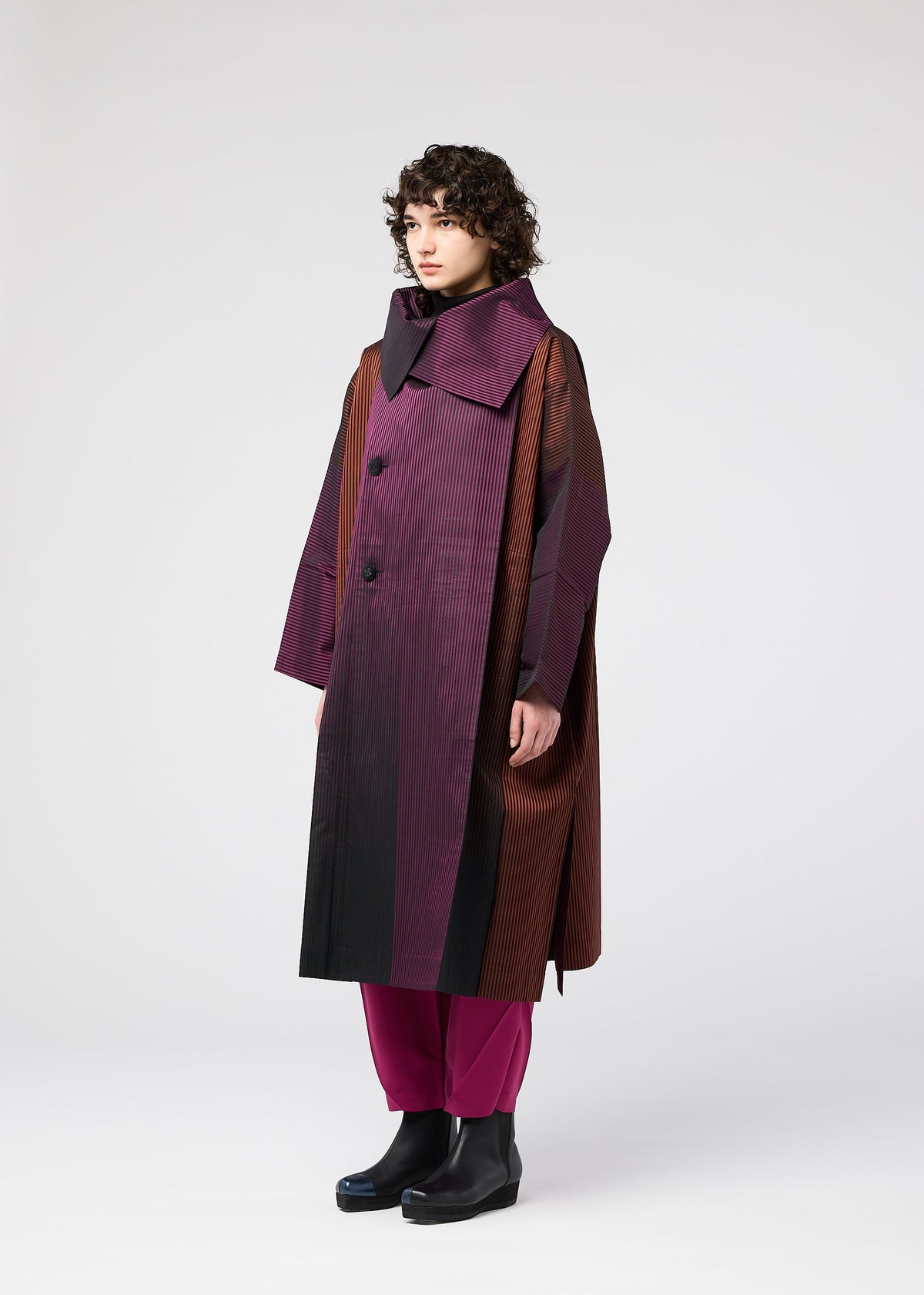 A model wears the 132 5. ISSEY MIYAKE GRADATION COAT clothing.