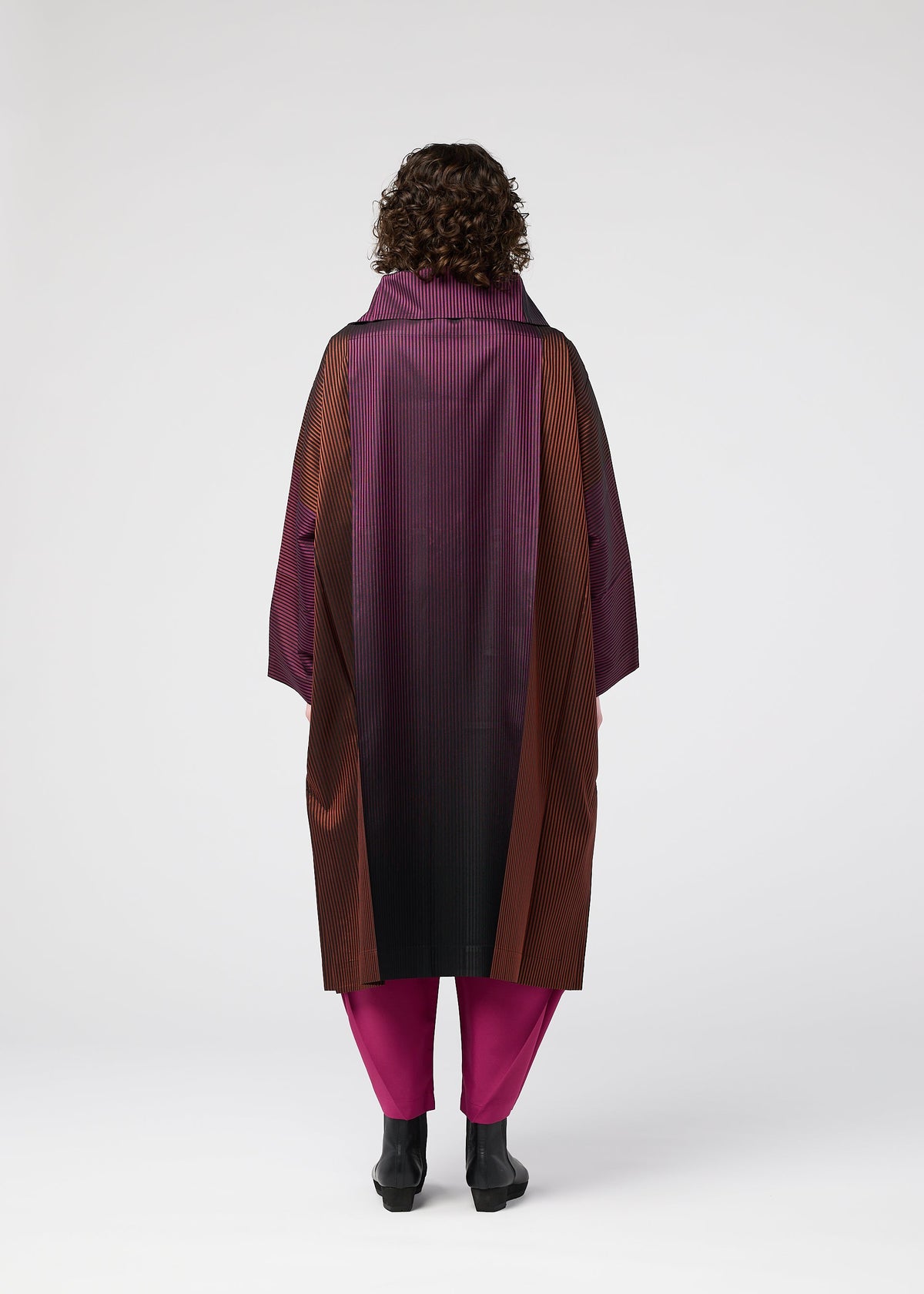 A model wears the 132 5. ISSEY MIYAKE GRADATION COAT clothing.