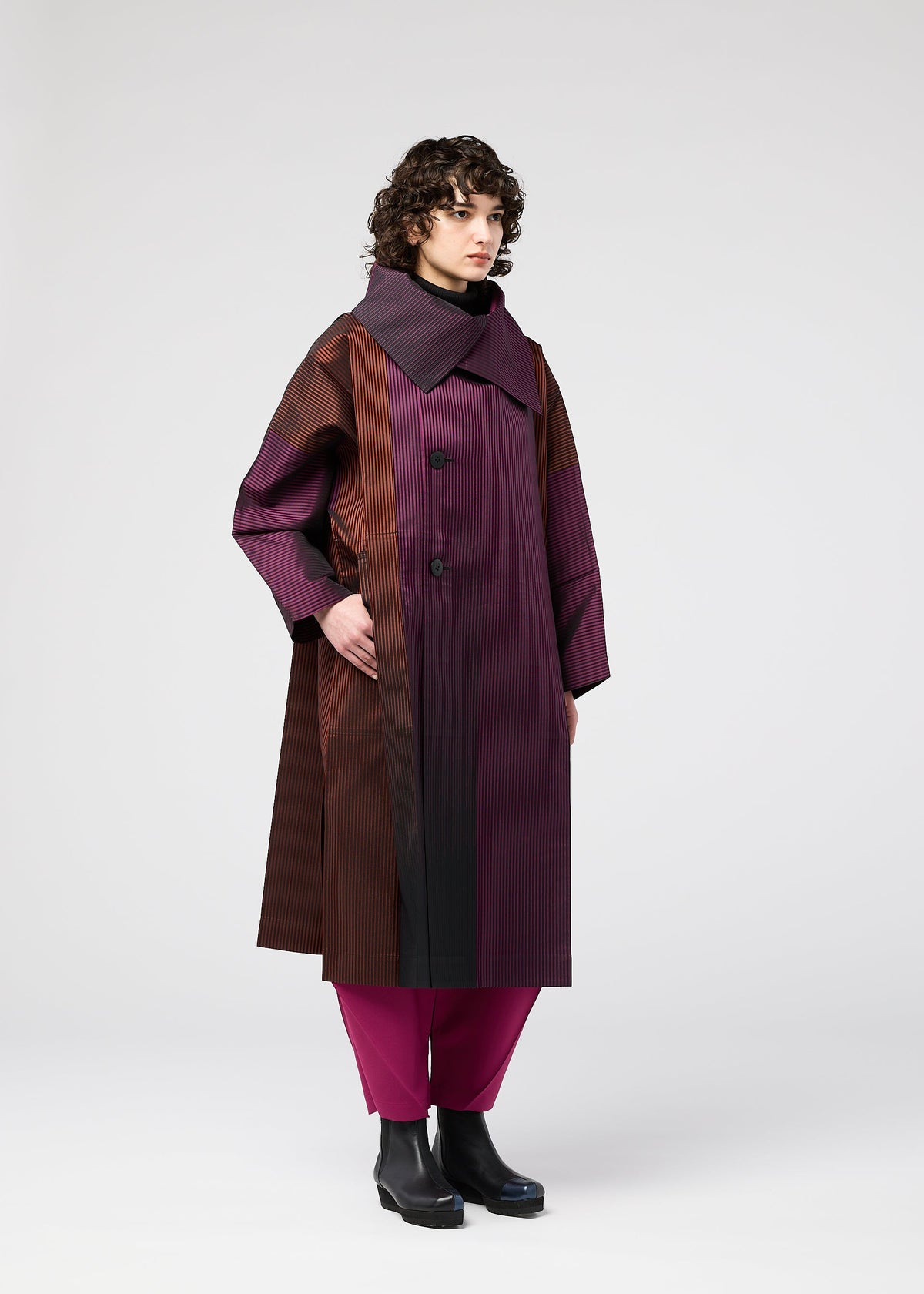 A model wears the 132 5. ISSEY MIYAKE GRADATION COAT clothing.