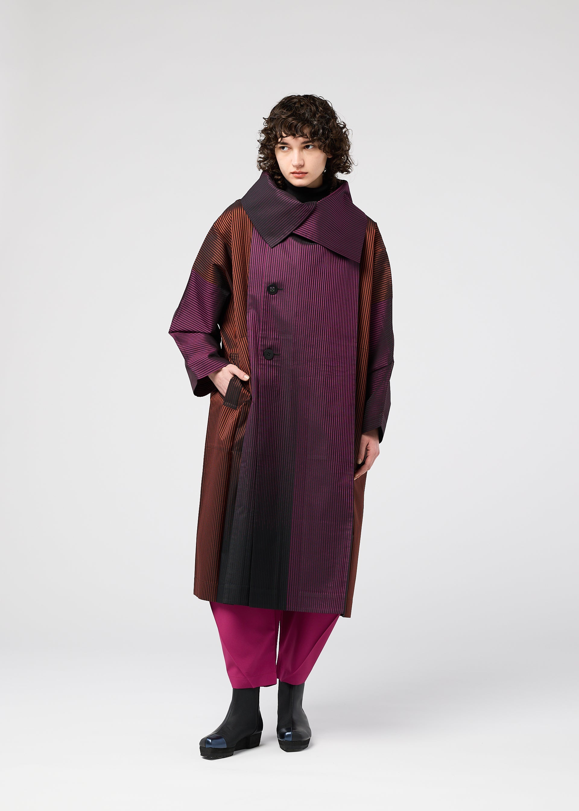 A model wears the 132 5. ISSEY MIYAKE GRADATION COAT clothing.