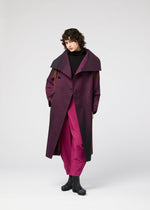 A model wears the 132 5. ISSEY MIYAKE GRADATION COAT clothing.