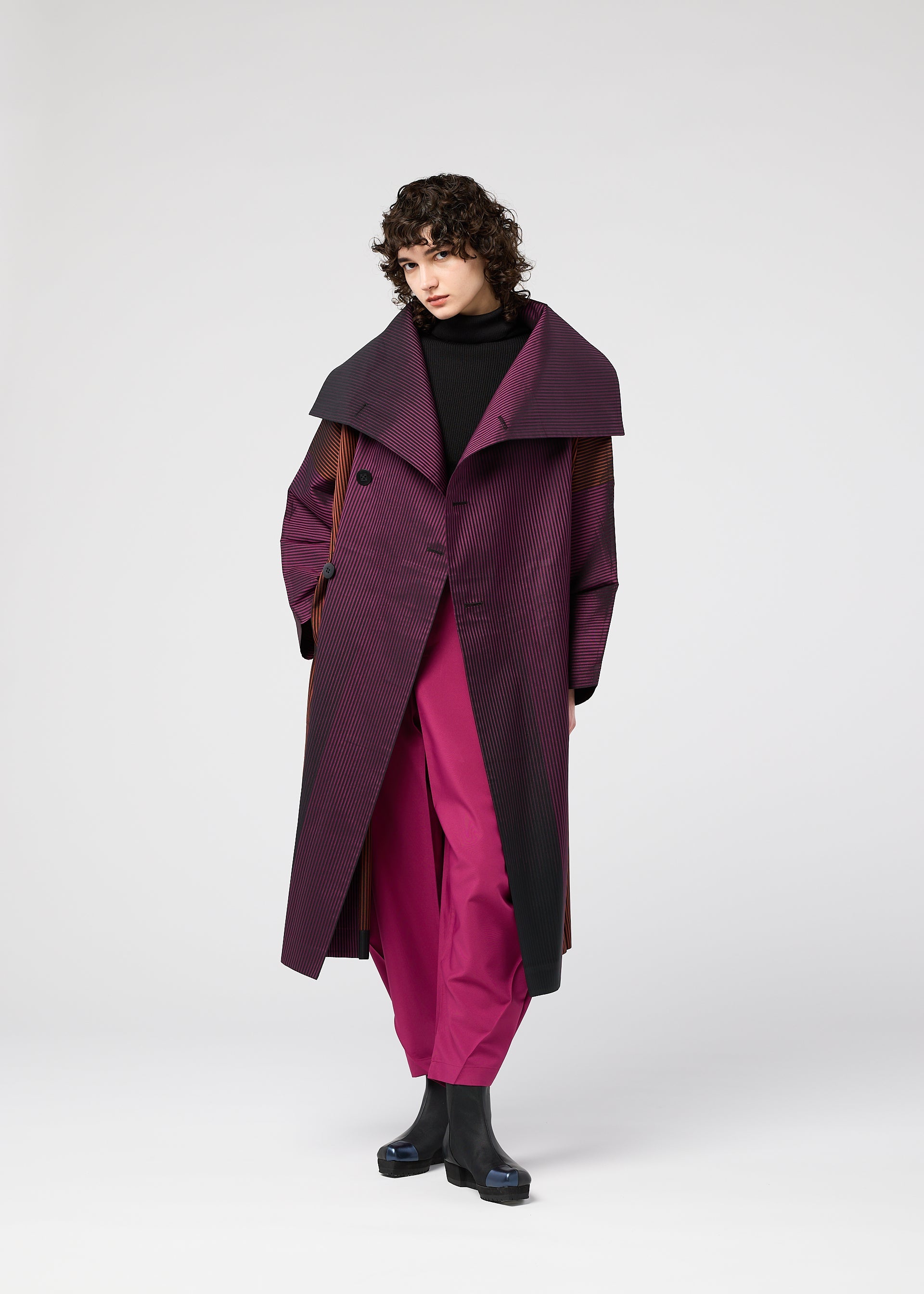 A model wears the 132 5. ISSEY MIYAKE GRADATION COAT clothing.