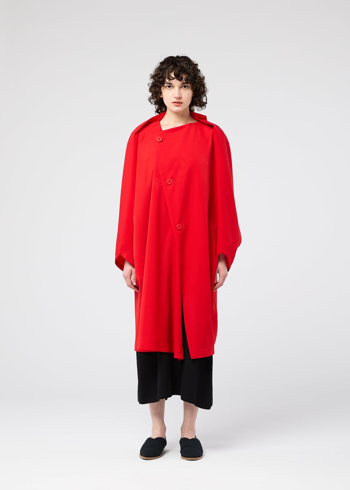 A model wears the 132 5. ISSEY MIYAKE PARALLEL WRAP coat.