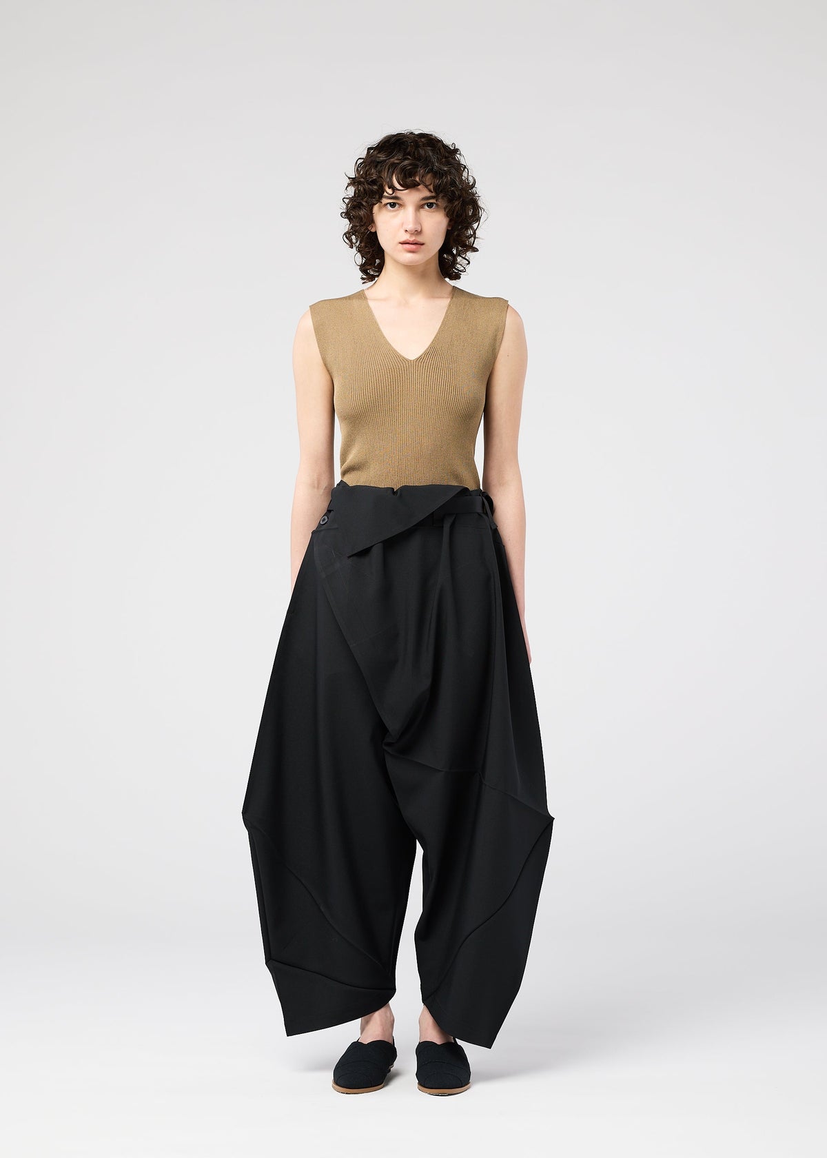 A model wears the 132 5. ISSEY MIYAKE FACET SOLID trousers.