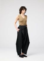 A model wears the 132 5. ISSEY MIYAKE FACET SOLID trousers.