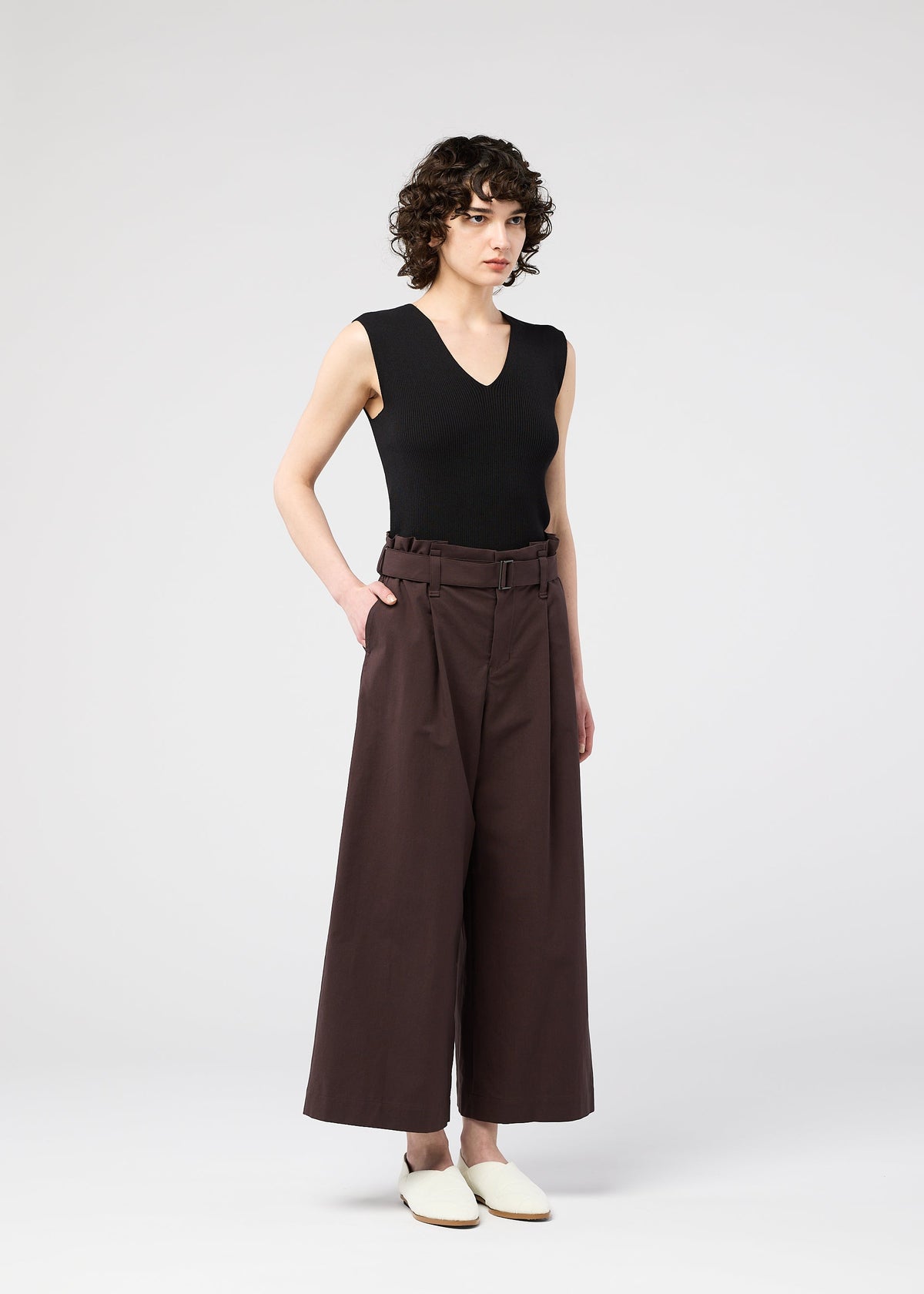 A model wears the 132 5. ISSEY MIYAKE WASHI STRETCH trousers.