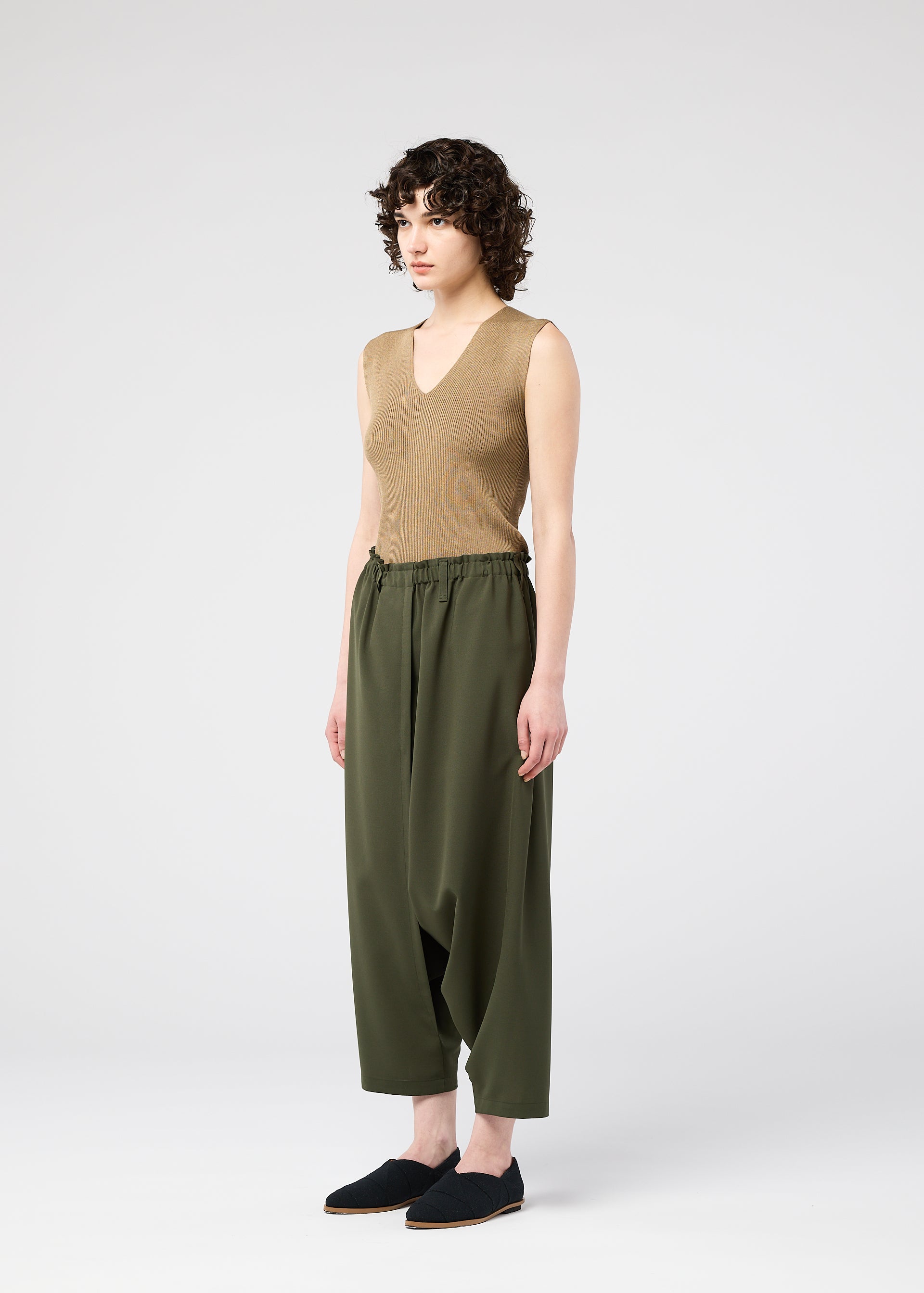 A model wears the 132 5. ISSEY MIYAKE SEAMLESS trousers.