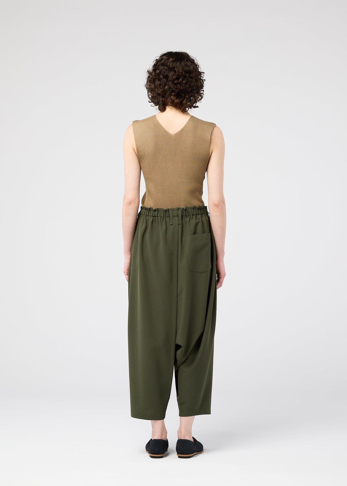 A model wears the 132 5. ISSEY MIYAKE SEAMLESS trousers.