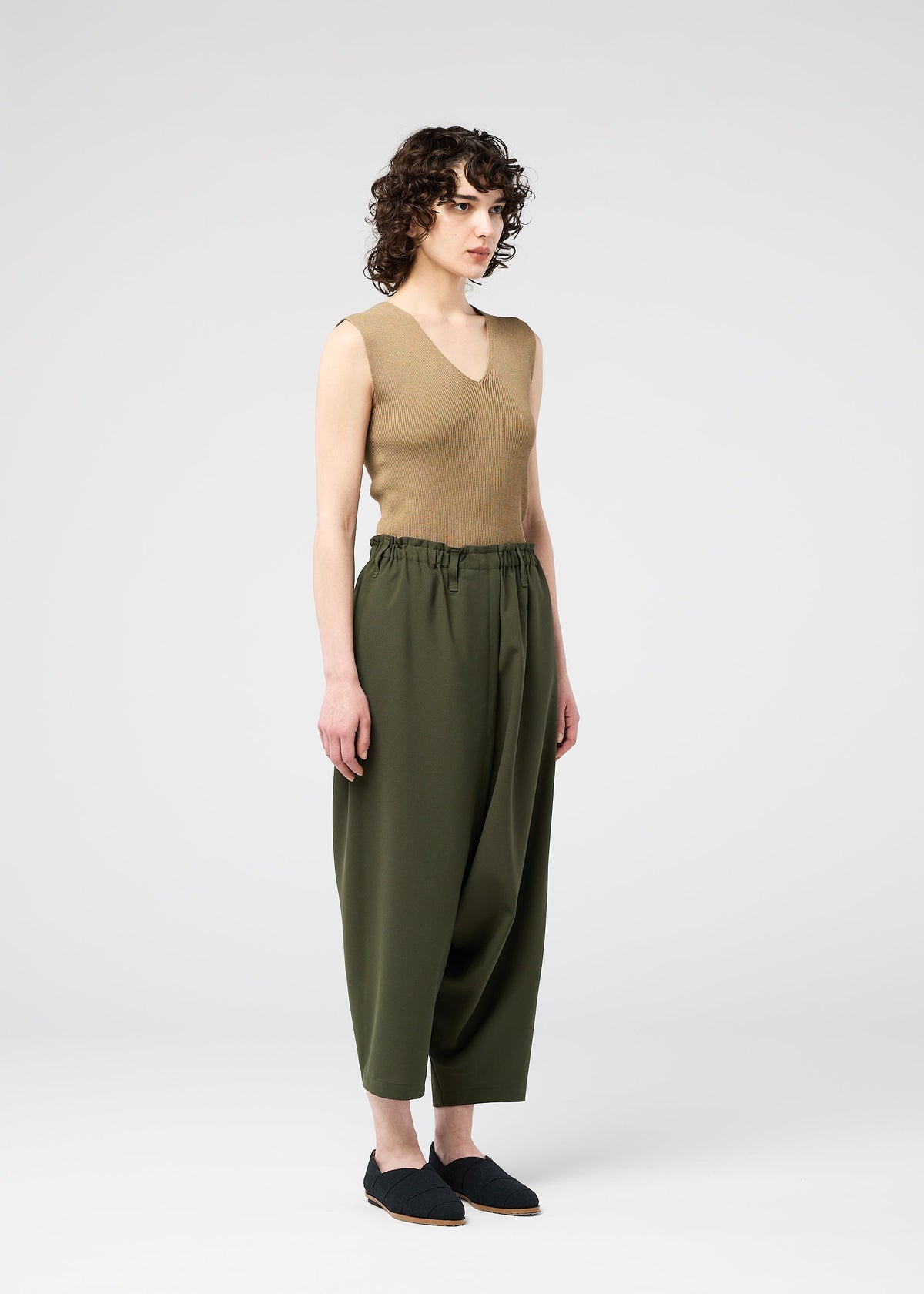A model wears the 132 5. ISSEY MIYAKE SEAMLESS trousers.