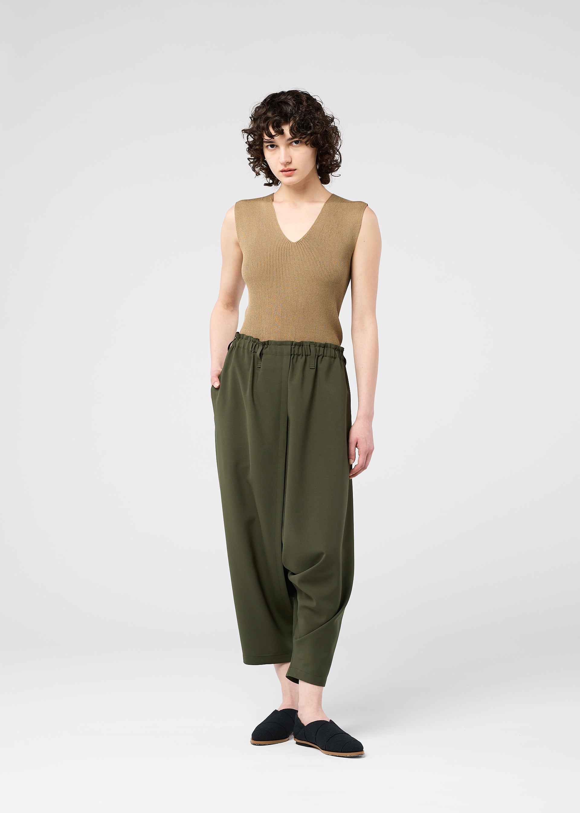 A model wears the 132 5. ISSEY MIYAKE SEAMLESS trousers.
