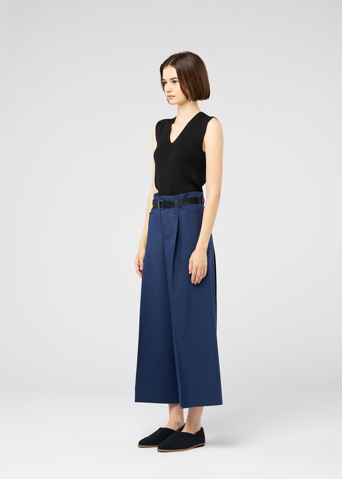A model wears the 132 5. ISSEY MIYAKE 132 5. FLAT 2 trousers.