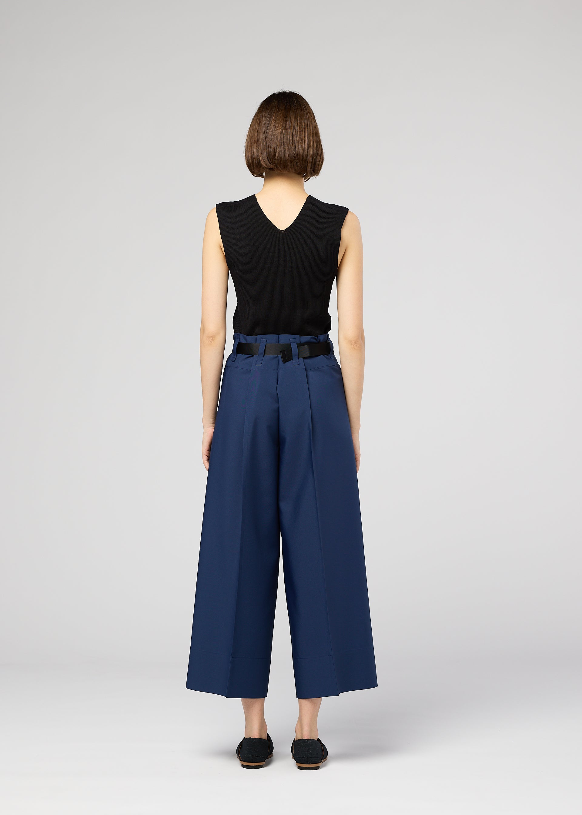 A model wears the 132 5. ISSEY MIYAKE 132 5. FLAT 2 trousers.