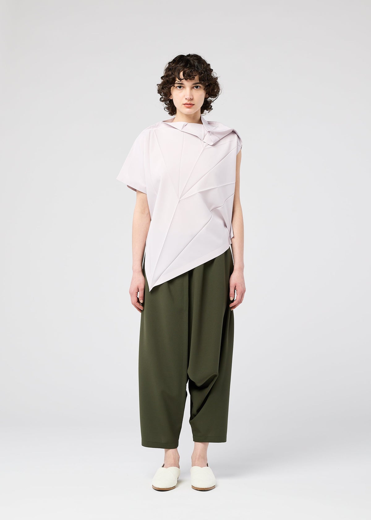 A model wears the 132 5. ISSEY MIYAKE RADIAL FOLD SHIRT top.