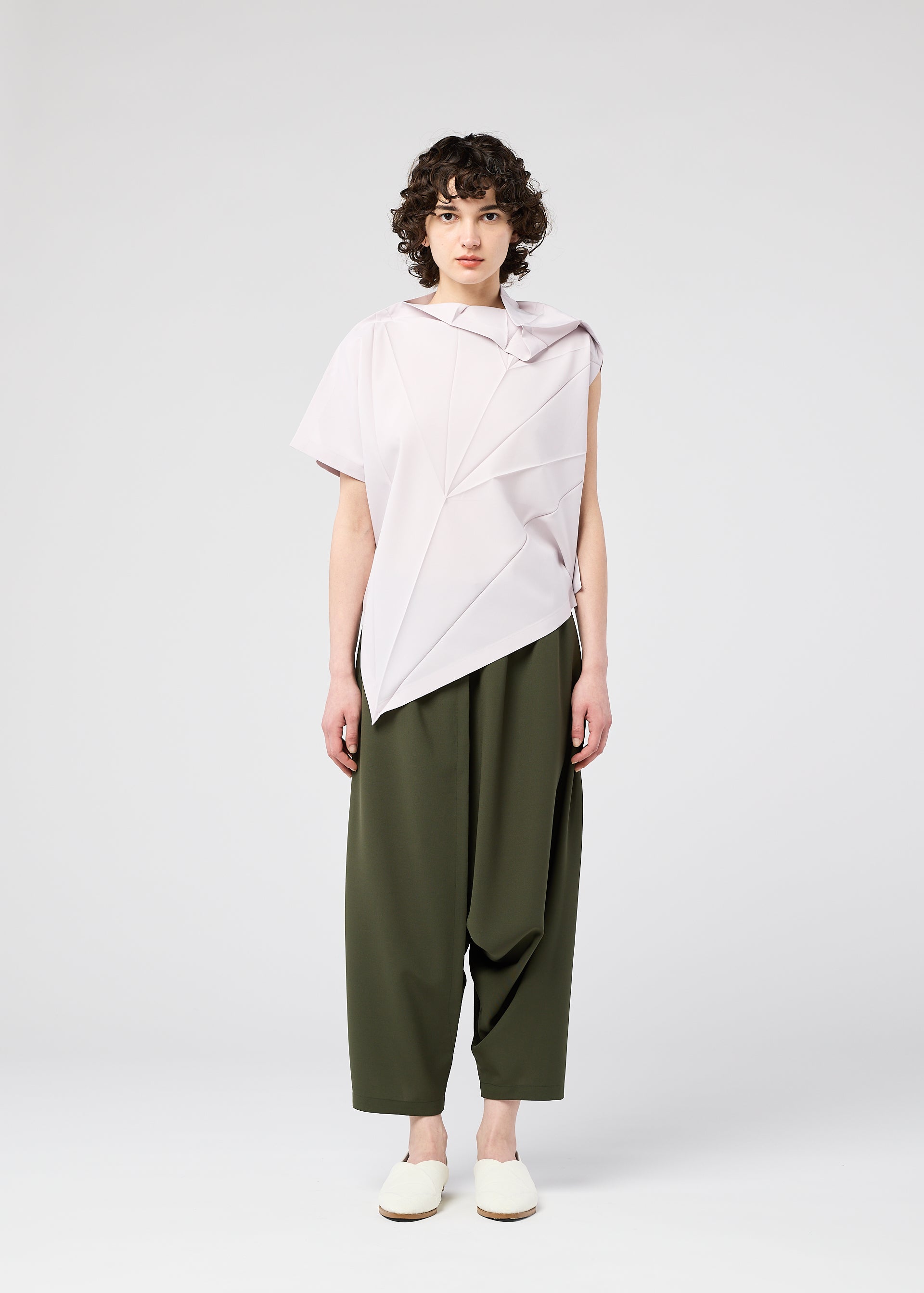 A model wears the 132 5. ISSEY MIYAKE RADIAL FOLD SHIRT top.