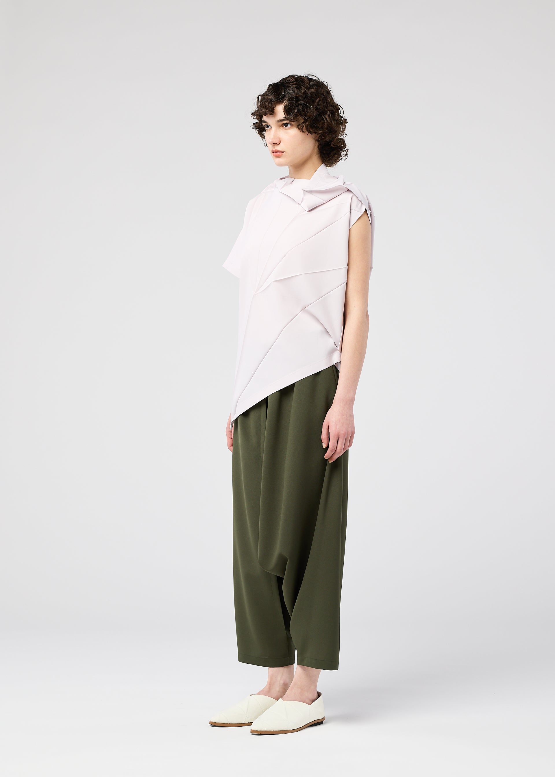 A model wears the 132 5. ISSEY MIYAKE RADIAL FOLD SHIRT top.