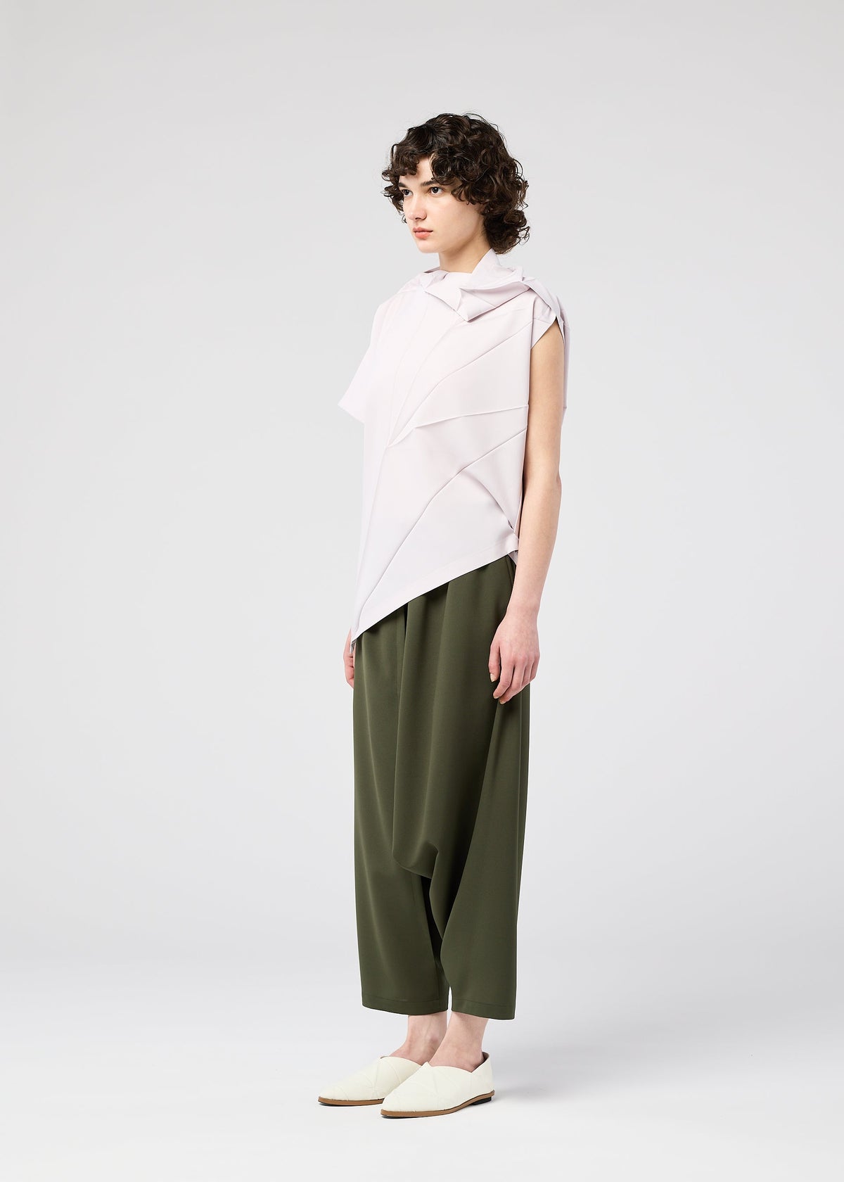 A model wears the 132 5. ISSEY MIYAKE RADIAL FOLD SHIRT top.