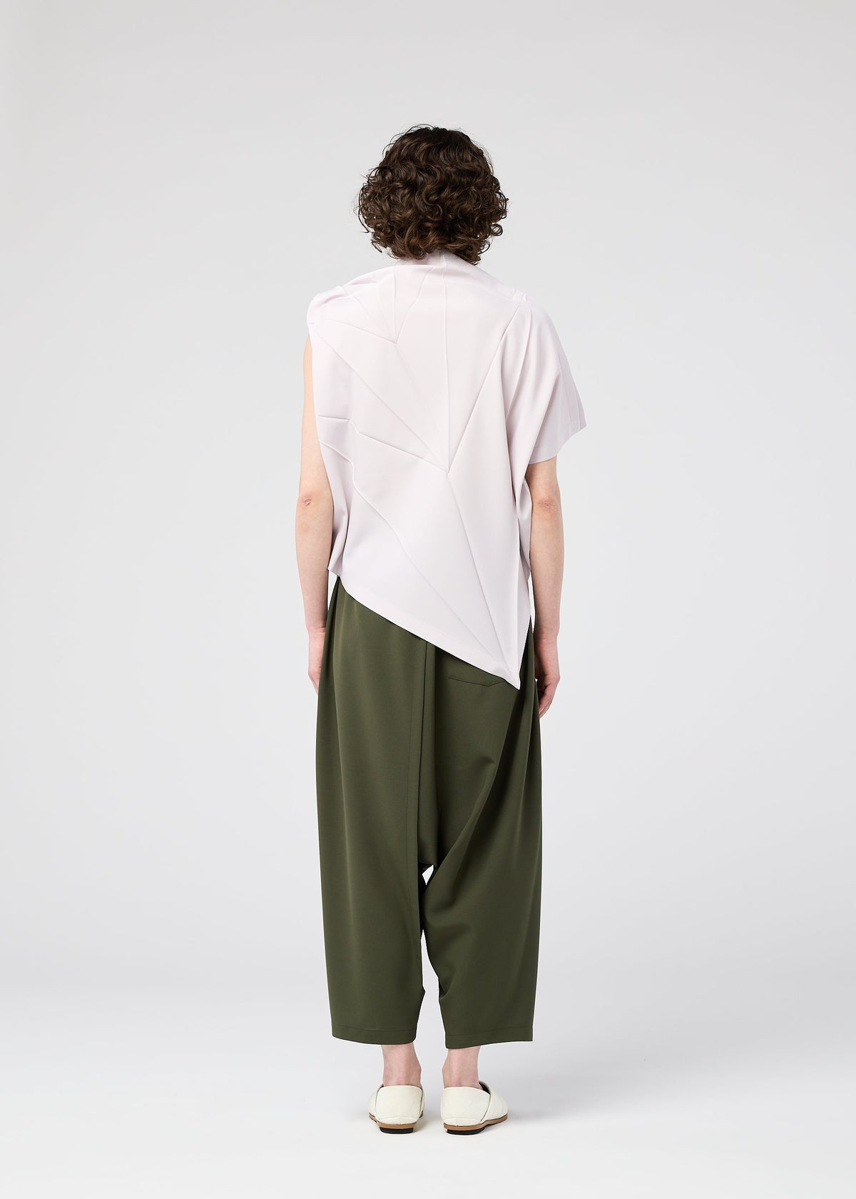 A model wears the 132 5. ISSEY MIYAKE RADIAL FOLD SHIRT top.