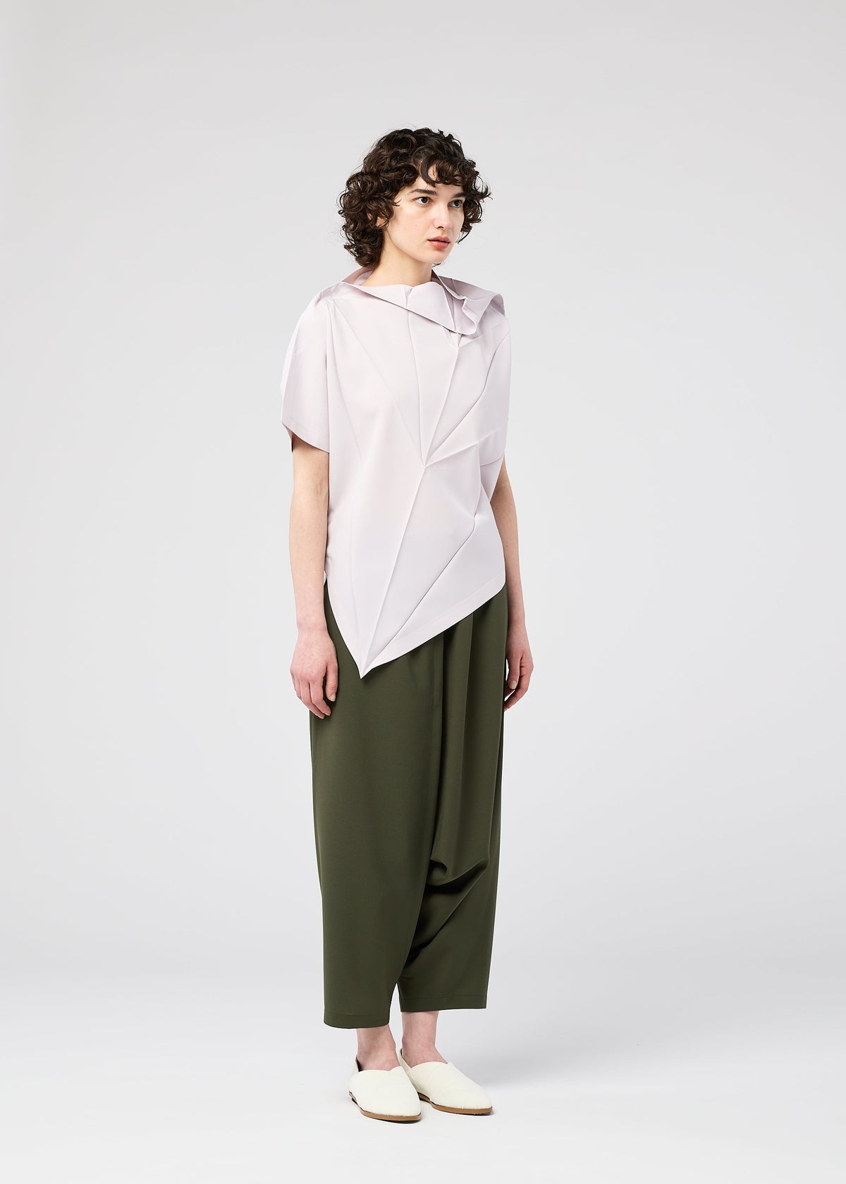 A model wears the 132 5. ISSEY MIYAKE RADIAL FOLD SHIRT top.
