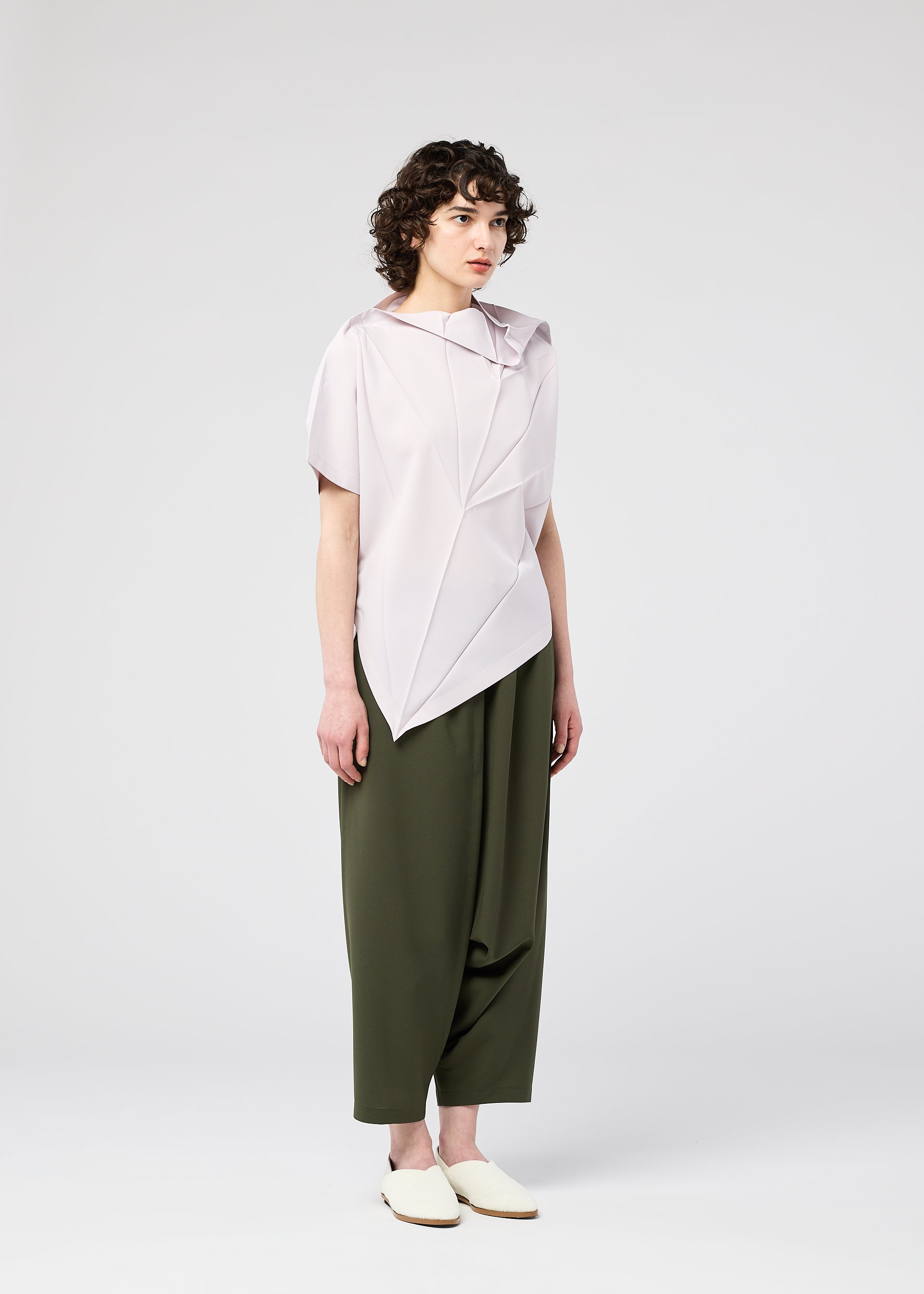 A model wears the 132 5. ISSEY MIYAKE RADIAL FOLD SHIRT top.
