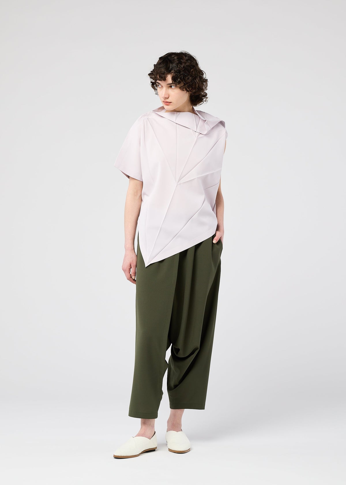 A model wears the 132 5. ISSEY MIYAKE RADIAL FOLD SHIRT top.