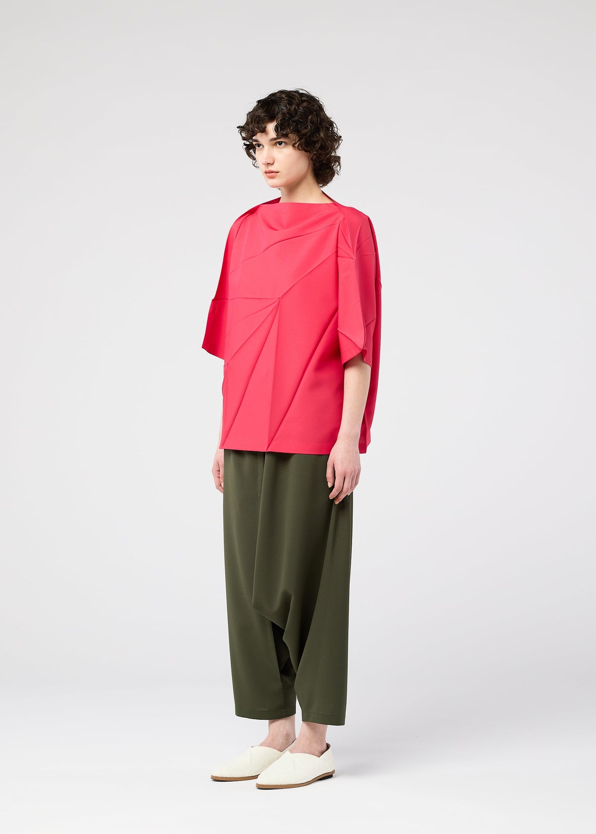 A model wears the 132 5. ISSEY MIYAKE RADIAL FOLD SHIRT top.