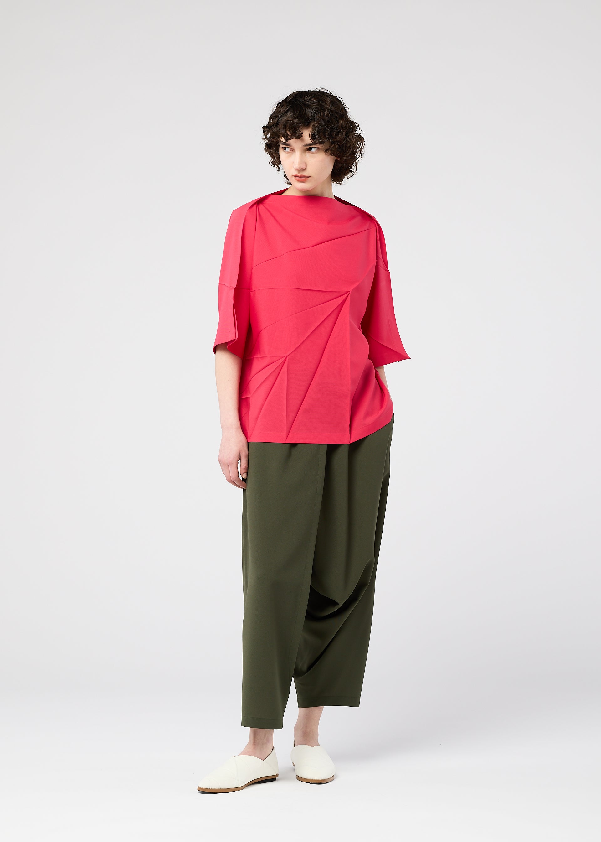A model wears the 132 5. ISSEY MIYAKE RADIAL FOLD SHIRT top.