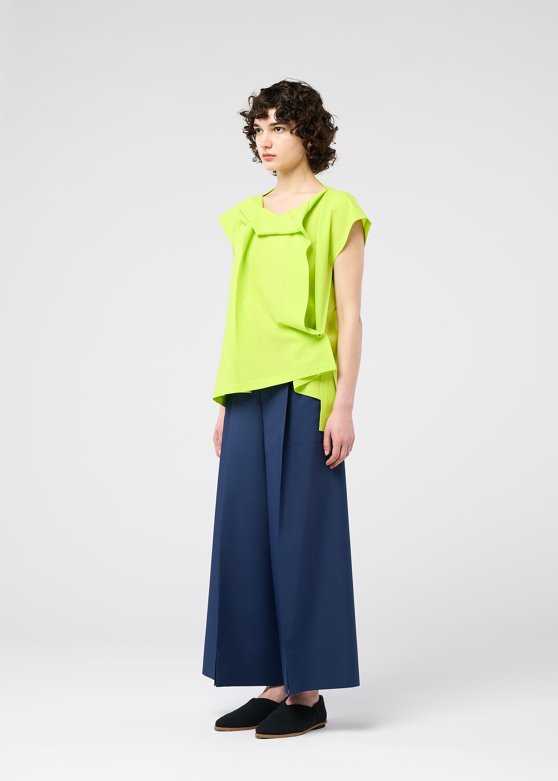 A model wears the 132 5. ISSEY MIYAKE FLAT TUCK T flat-tuck-t-shirt-yellow-green.